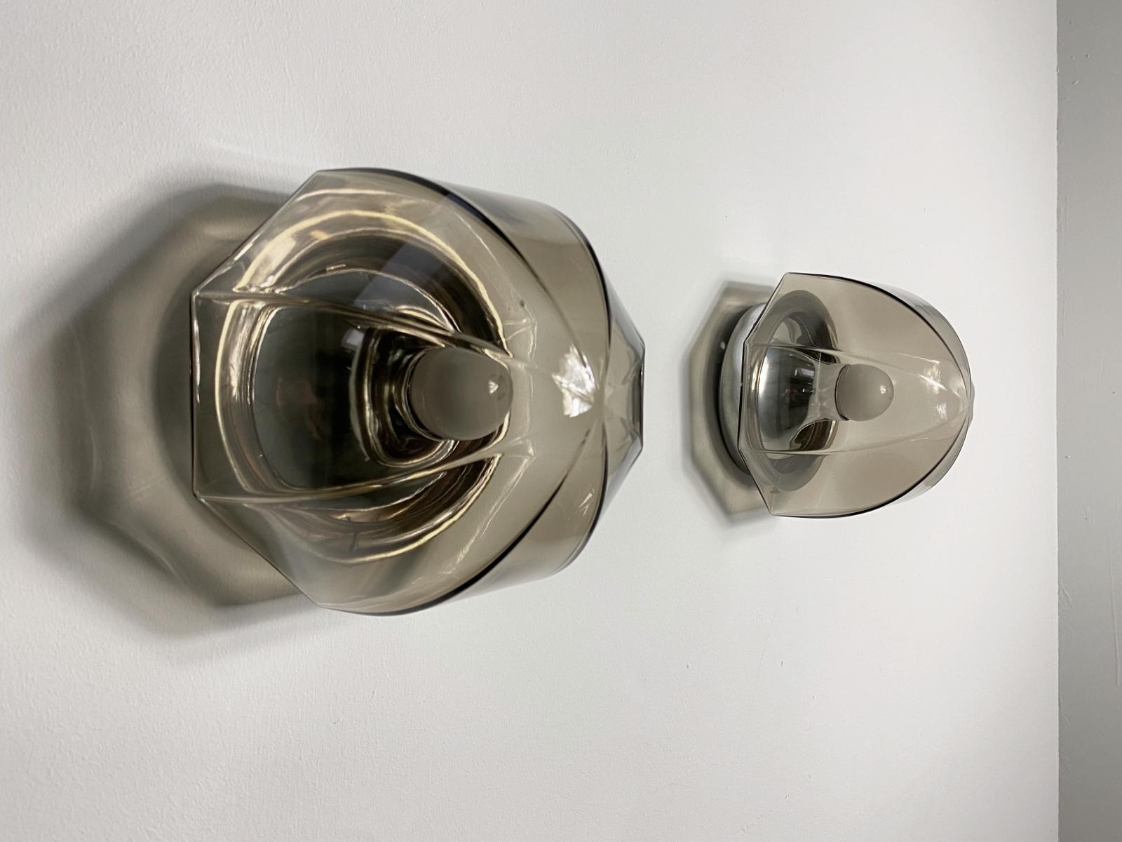 Beautiful wall or ceiling lamps manufactured by Hillebrand in 1970s. Featuring a chrome reflective base with a hand blown smoked glass shade.
Fully working and tested condition with one E27 Edison socket, the lamp work on 220V and 110V. 

