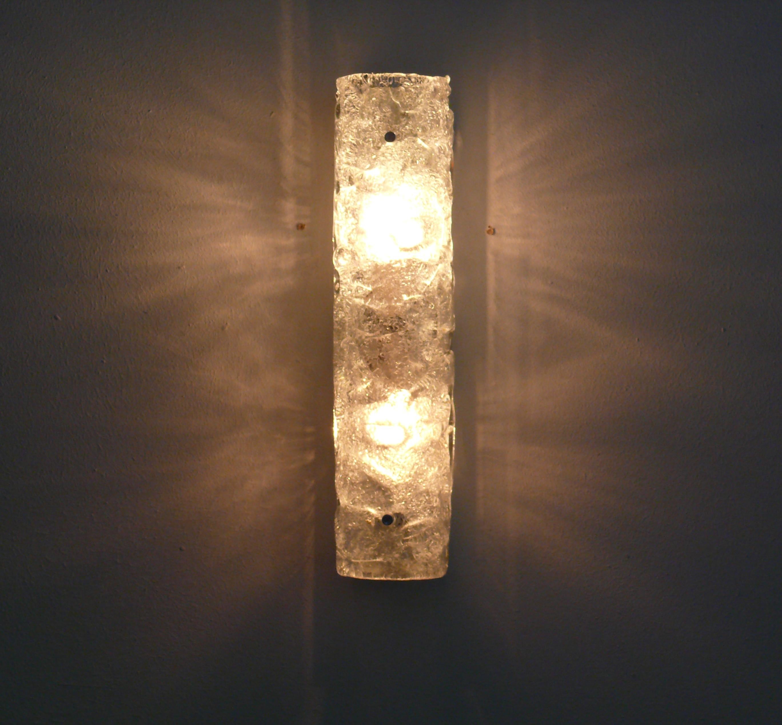 Long and beautiful wall sconce made of German Murano ice glass by Egon Hillebrand, model: 8527-231. This wall sconce consists of a brass bracket and a piece of Murano glass. 
The lamp is equipped with 2 lamp holders (E14). The lamp has a heavy shade