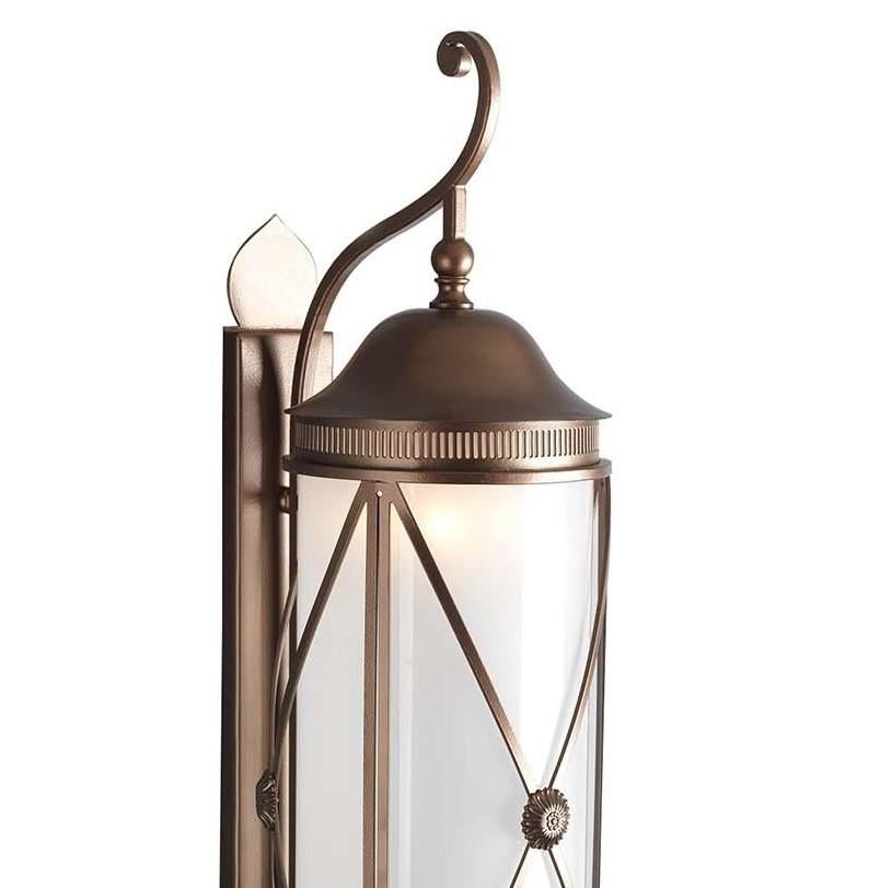This elegant wall lantern is a striking object of functional decor that will illuminate al fresco dinners on a patio, or flank the entrance door of a house, creating a welcoming and timeless decoration. Its structure is made of forged stainless