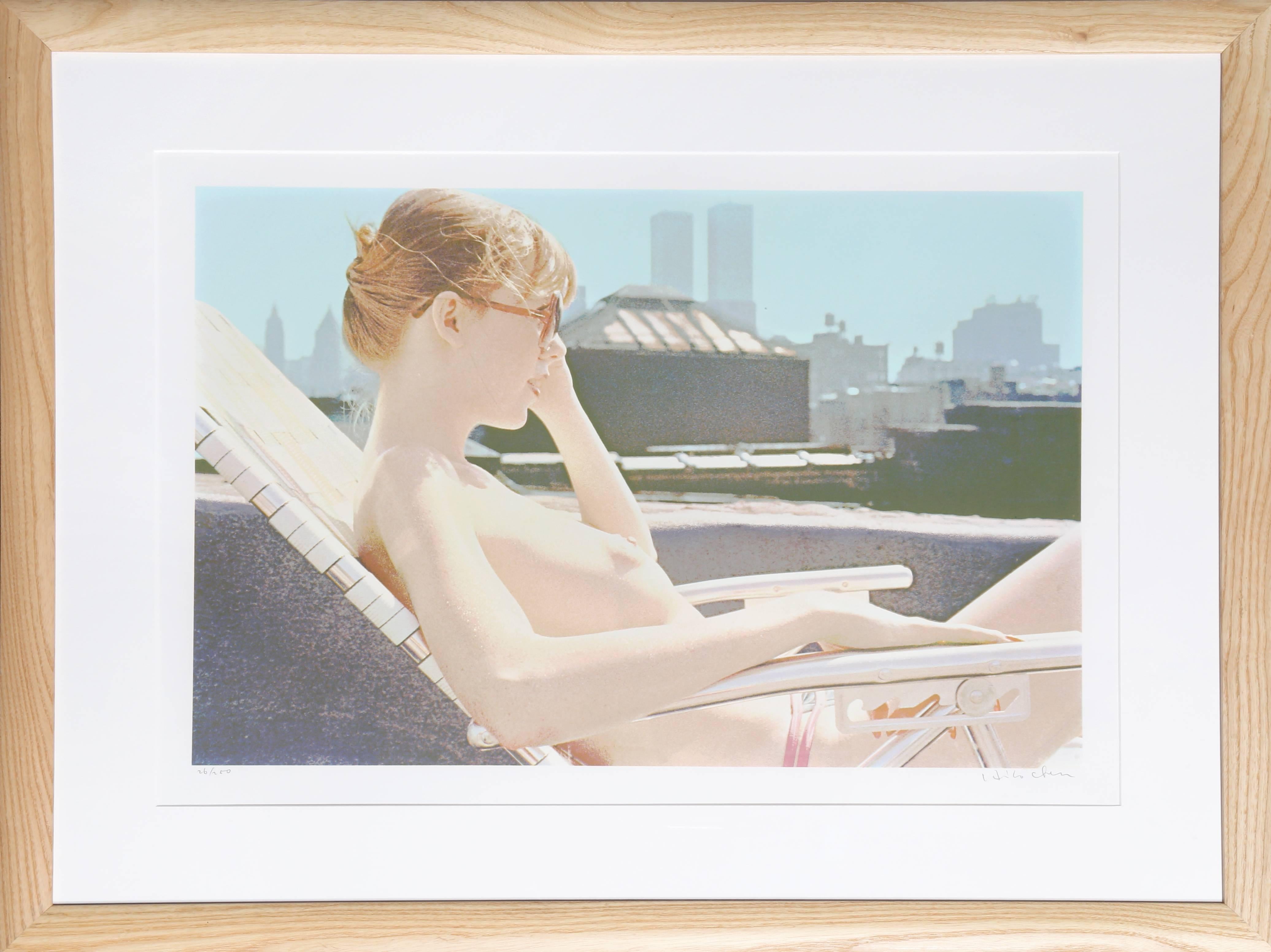 A topless woman basking in the sun on an NYC rooftop. In the distance behind her, the twin towers are visible.

Artist: Hilo Chen
Title: Rooftop Sunbather from the City Scapes Portfolio
Year: 1981
Medium: Silkscreen on White Somerset Satin, signed