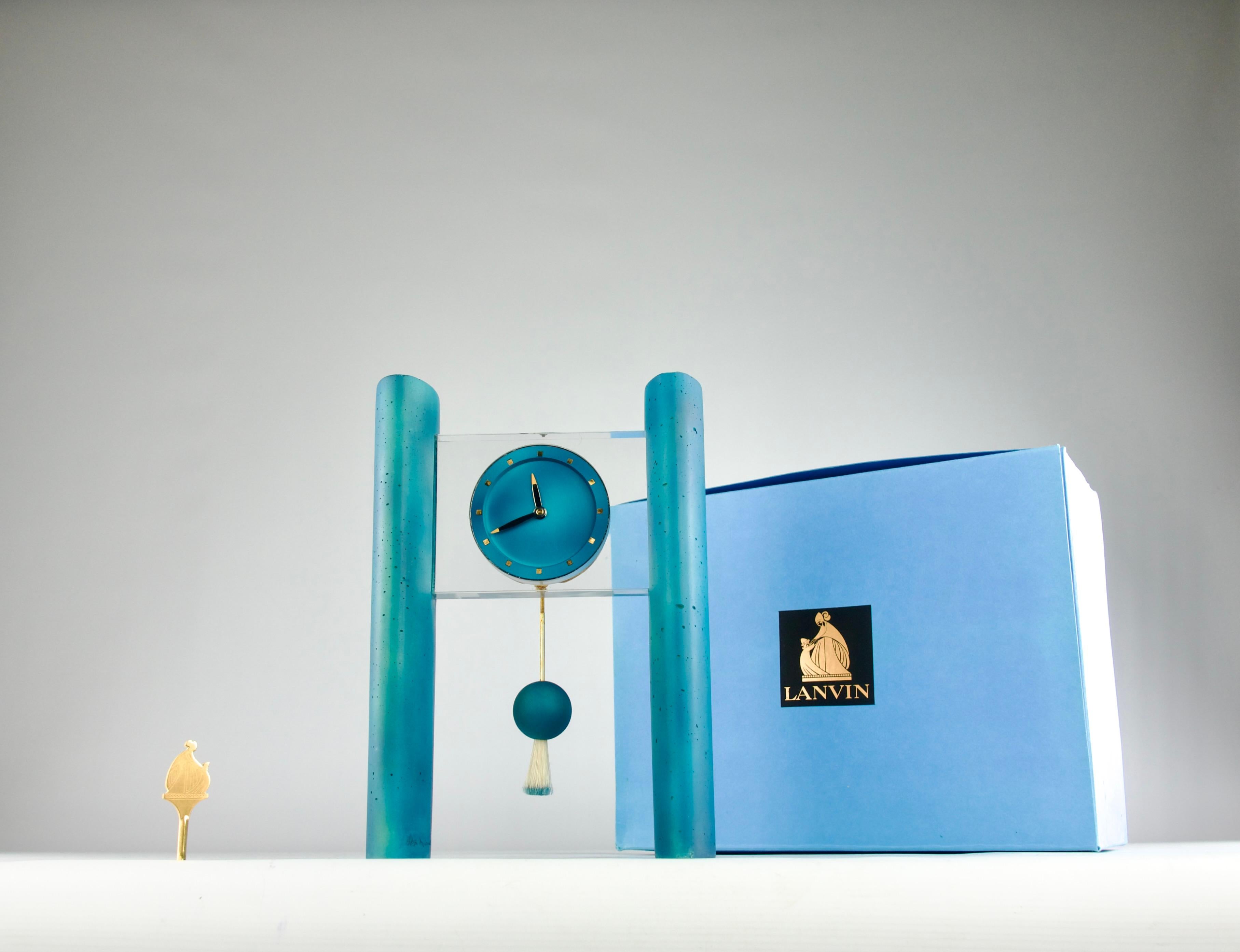 Superbe et extrêmement rare pendule de cheminée Memphis mid-century design en ciment bleu, poils de castor et plexiglas par Hilton McConnico pour Lanvin, fabriquée par Hour Lavigne en 1992. L'horloge est signée et numérotée 29/50.

Dans sa boîte