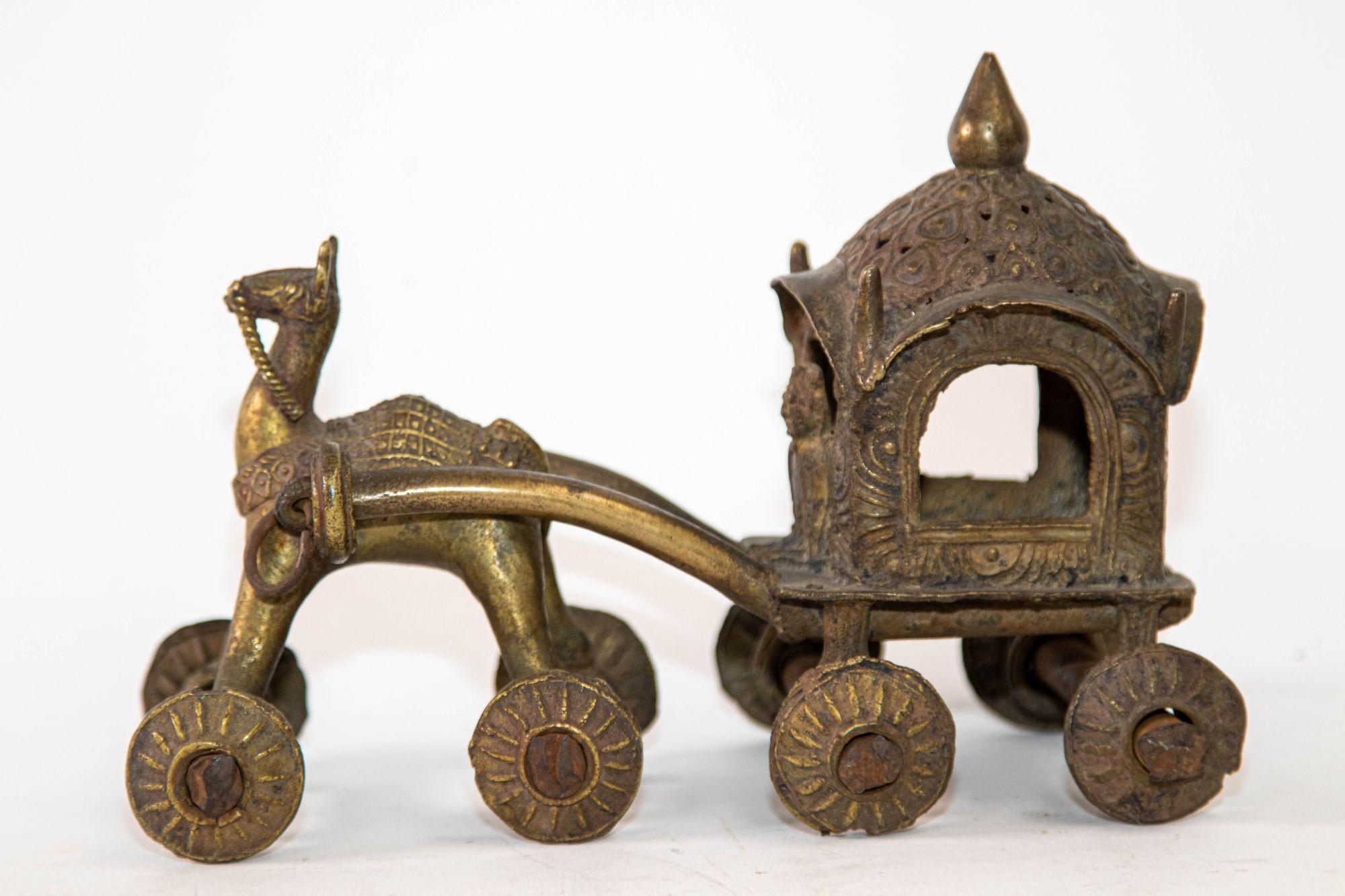 Antique hindu bronze Temple horse and chariot statue toy on wheels.
This collectible bronze temple toy horse is heavy and the sculptural details are full of artisanal charm and irregularities.
The wheels turn independently of the iron axles, and it
