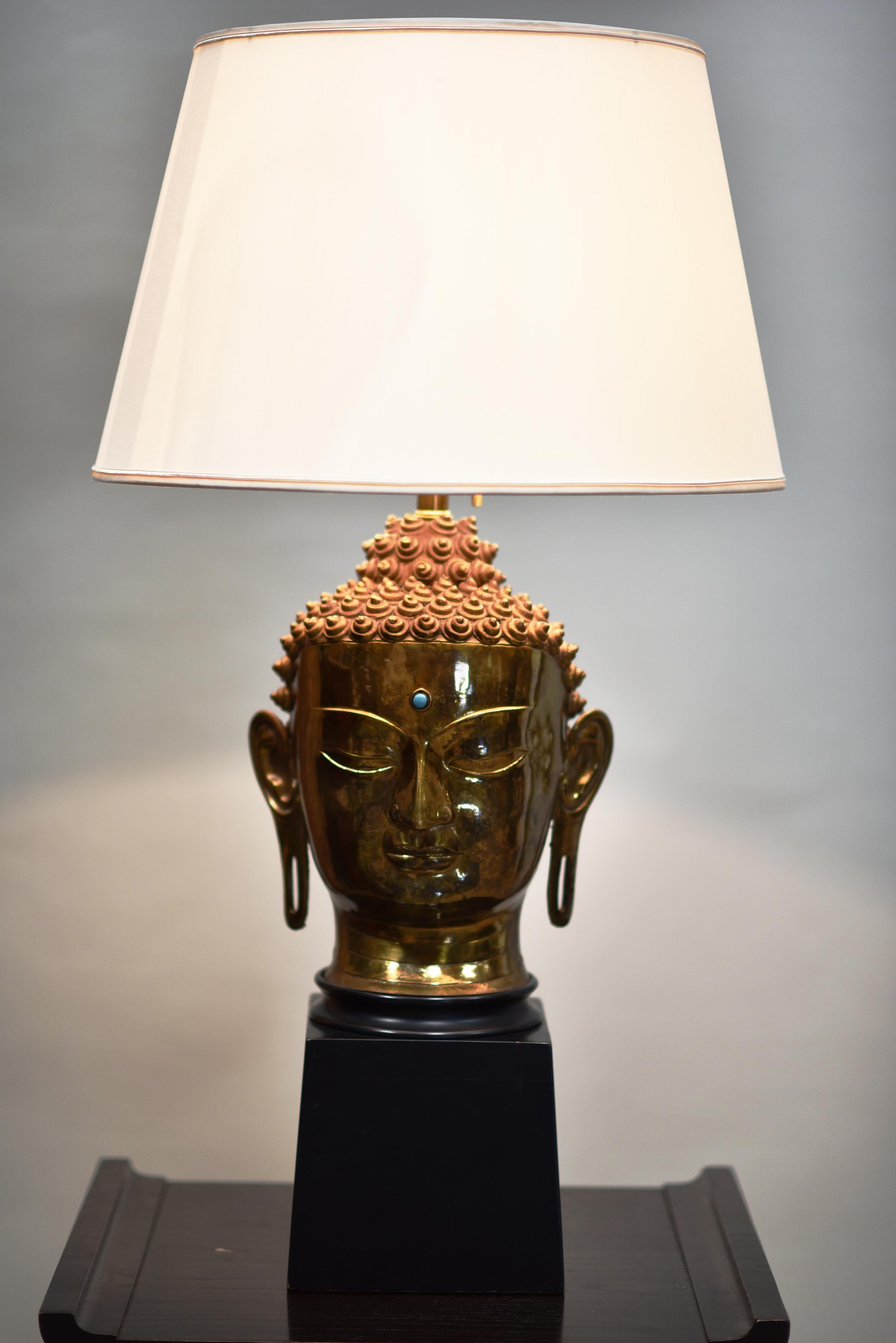 Artist and manufacturer are unknown. This is a beautiful single Hindu head lamp in brass and wood with distinctive marks in headdress and adornments with a jewell in the center of the buddha's head.