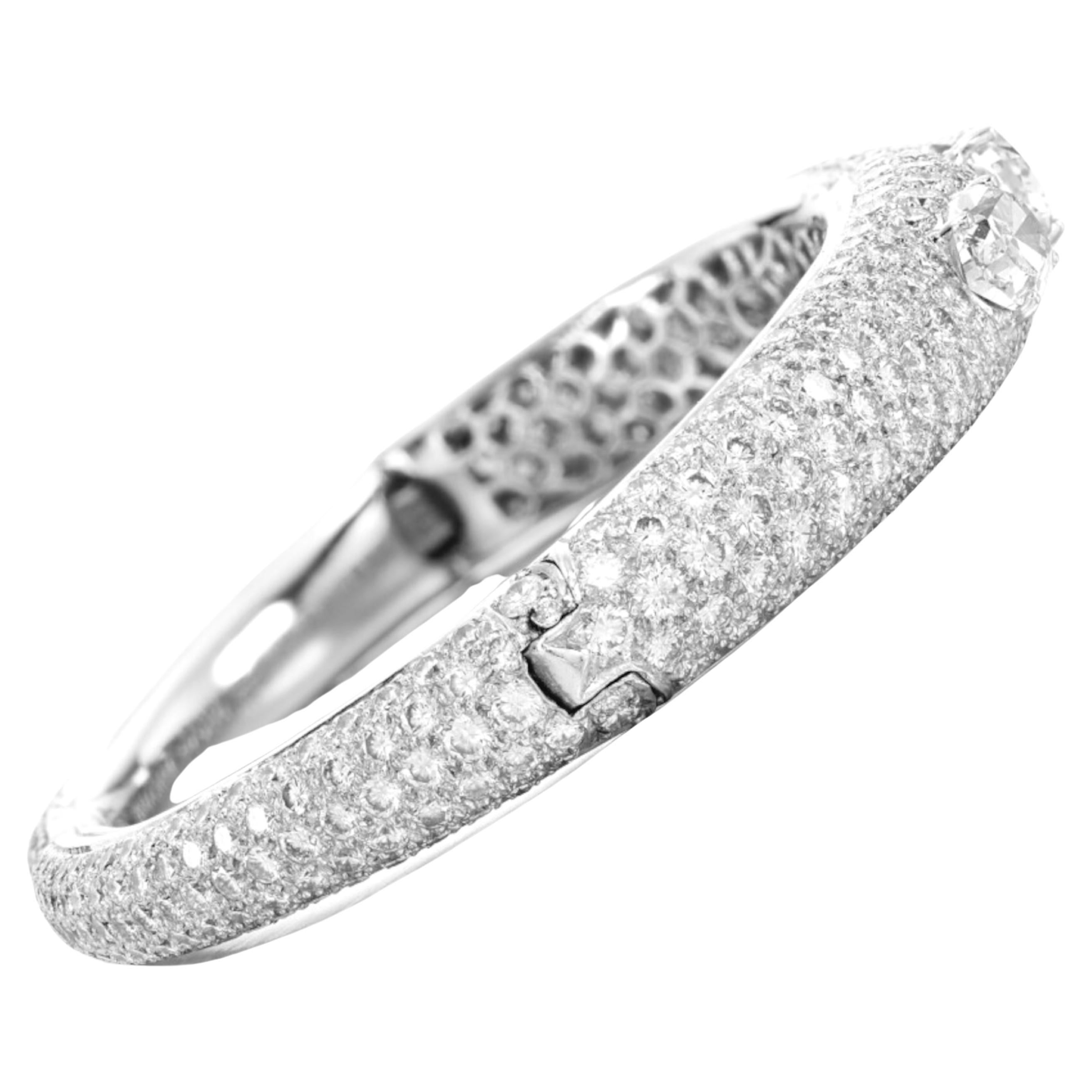 Voici l'exquis bracelet à charnière, véritable témoignage de luxe et d'élégance. Pavée de diamants taille brillant, cette magnifique pièce est rehaussée de trois diamants ovales captivants de 1,50, 1,60 et 2,75 carats. Avec une circonférence