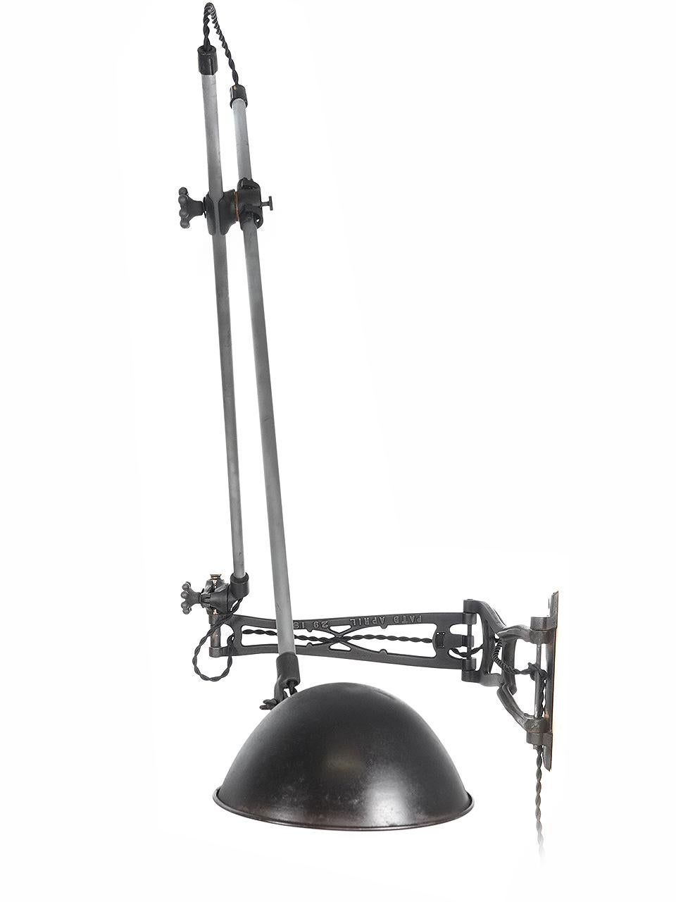 This articulated arm lamp is an O.C. White and its a good one. These lamps have always been sought after by collectors. It has 2 pipe arms using 2 unique style articulating fittings with 2 ball know fittings. This is all connected to a hinged cast