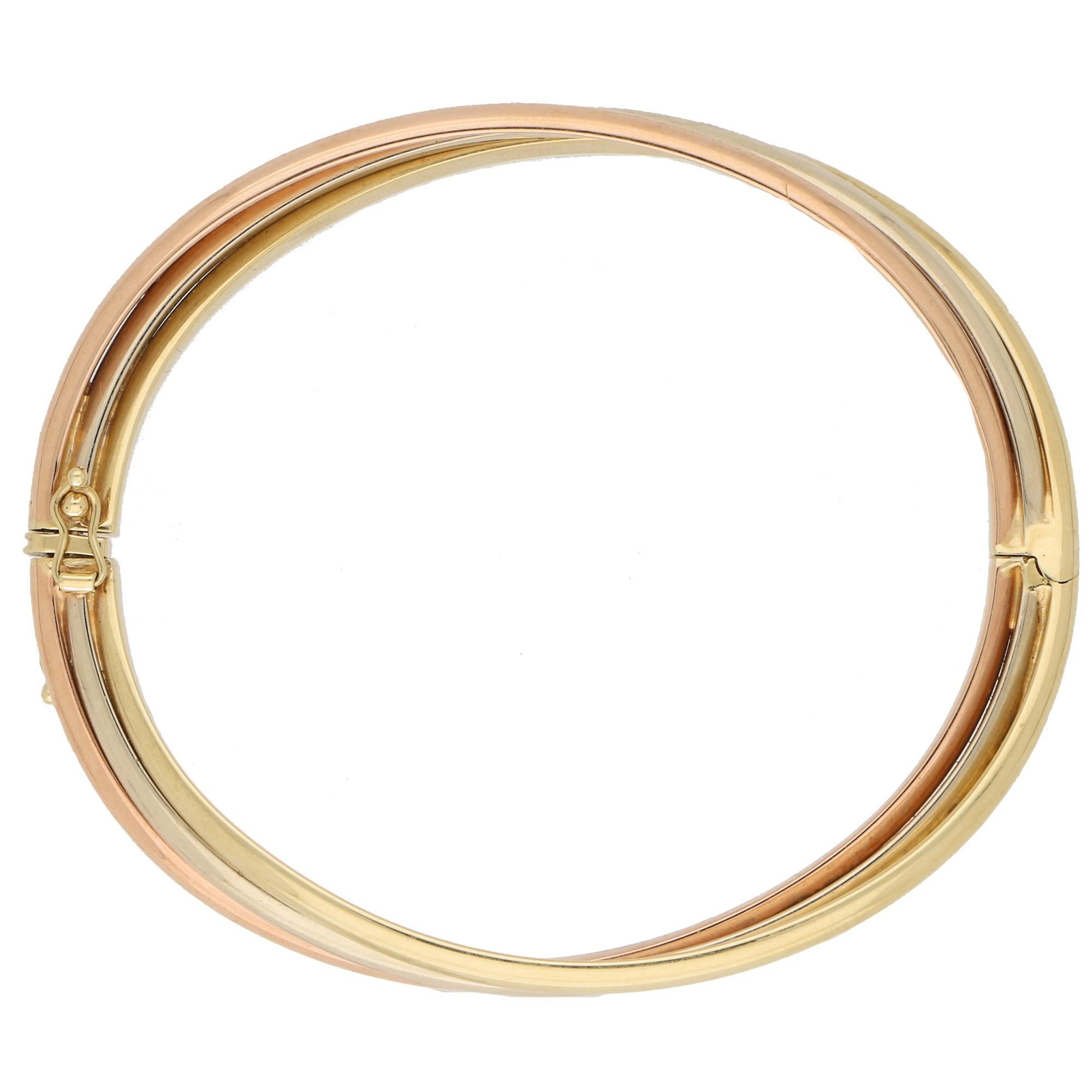 A beautiful hinged trinity bangle set in 9k yellow, rose and white gold. 

The bangle is composed of three soldered tri-colored bangles which are all interlocked together in the iconic trinity design.  If you love the trinity design but aren't so