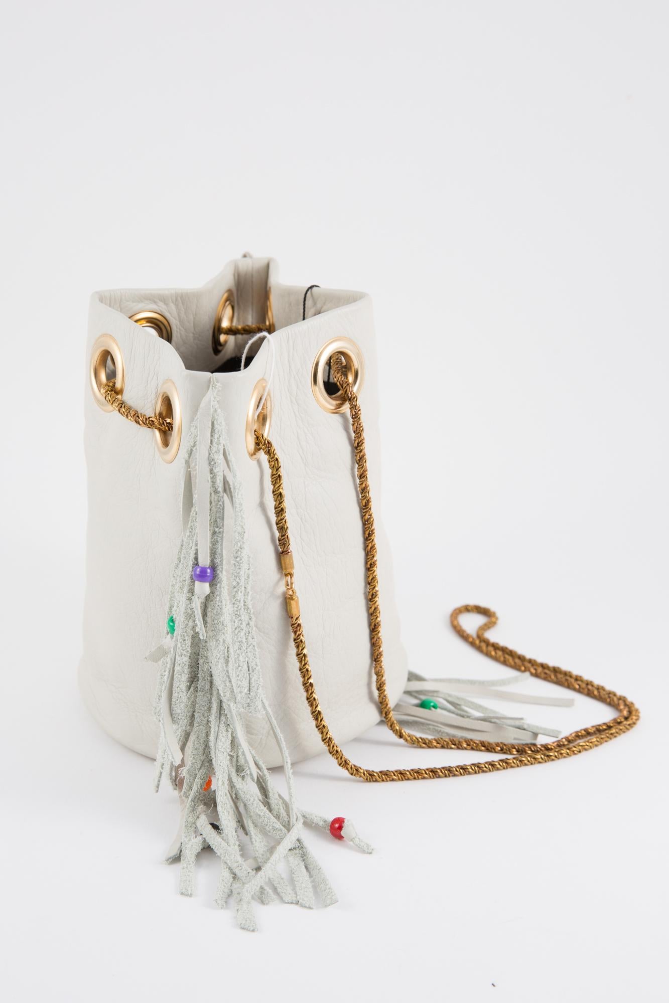 Hippy look Delphine Delafon off white leather shoulder bag featuring leather fringes with multi beads, a gold tone shoulder strap (51.3in. (130cm)), 
Hauteur: 19cm
Bottom Diameter 6.7in. (17cm)
Total shoulder strap (51.3in. (130cm)
In excellent