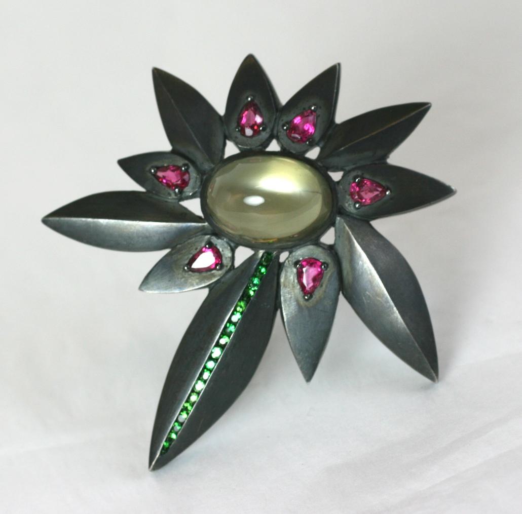 Amazing Artisanal brooch by Hiroko in heavy patinaed sterling with massive albinite moonstone 20mm x 15 mm x 10mm high cabochon. Abstract hand made floriform design with green garnets and pink tourmalines. 
Marked 925. Signed Hiroko.  2.75 x 3 high,