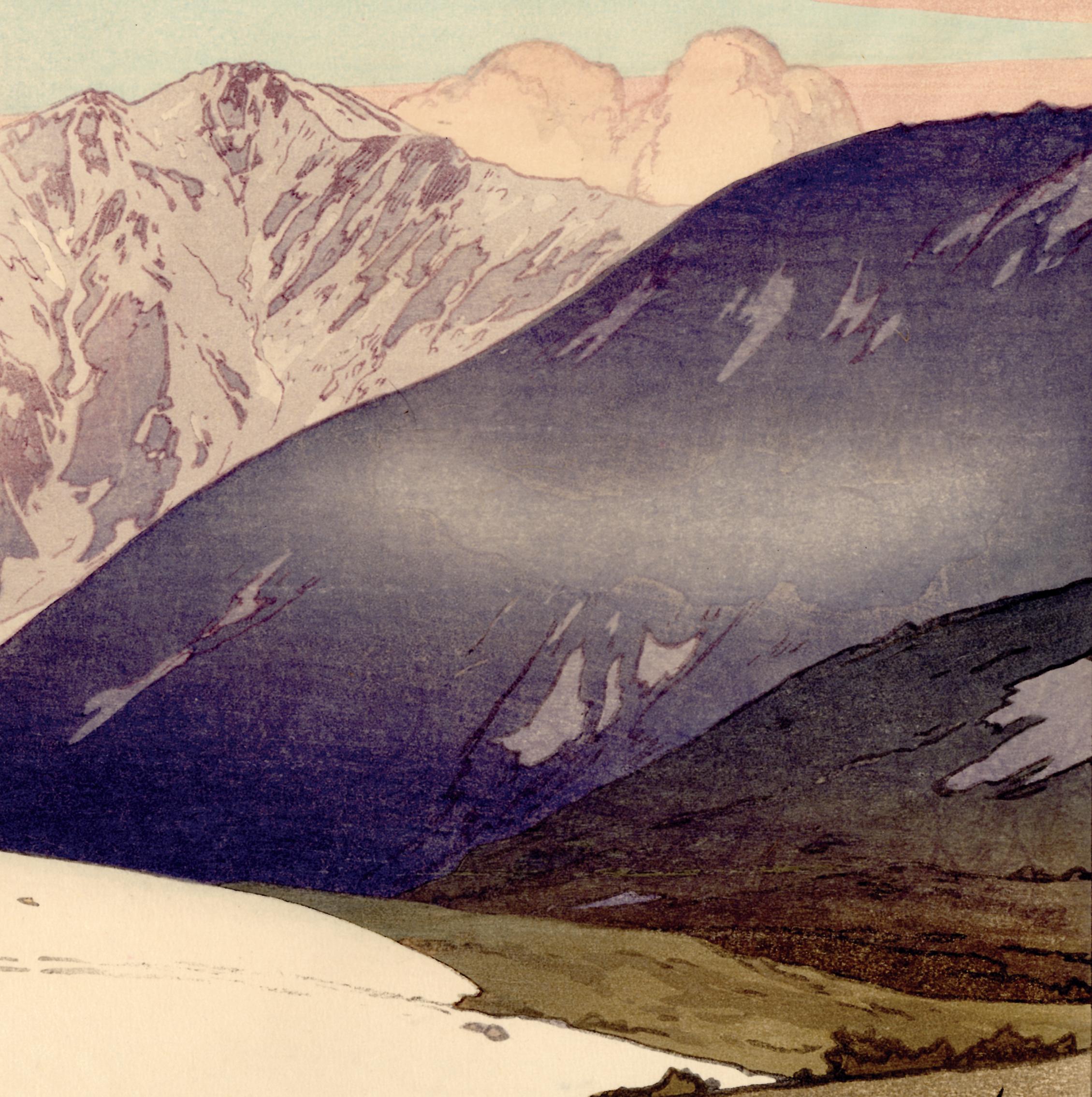 Original handmade Japanese woodblock print. Tateyama Betsuzan. We see smoke issuing from huts on a mountain expanse,  a region of snow nearby. A cloud hovers left and right, and every surrounding peak has different colors and textures. The printing