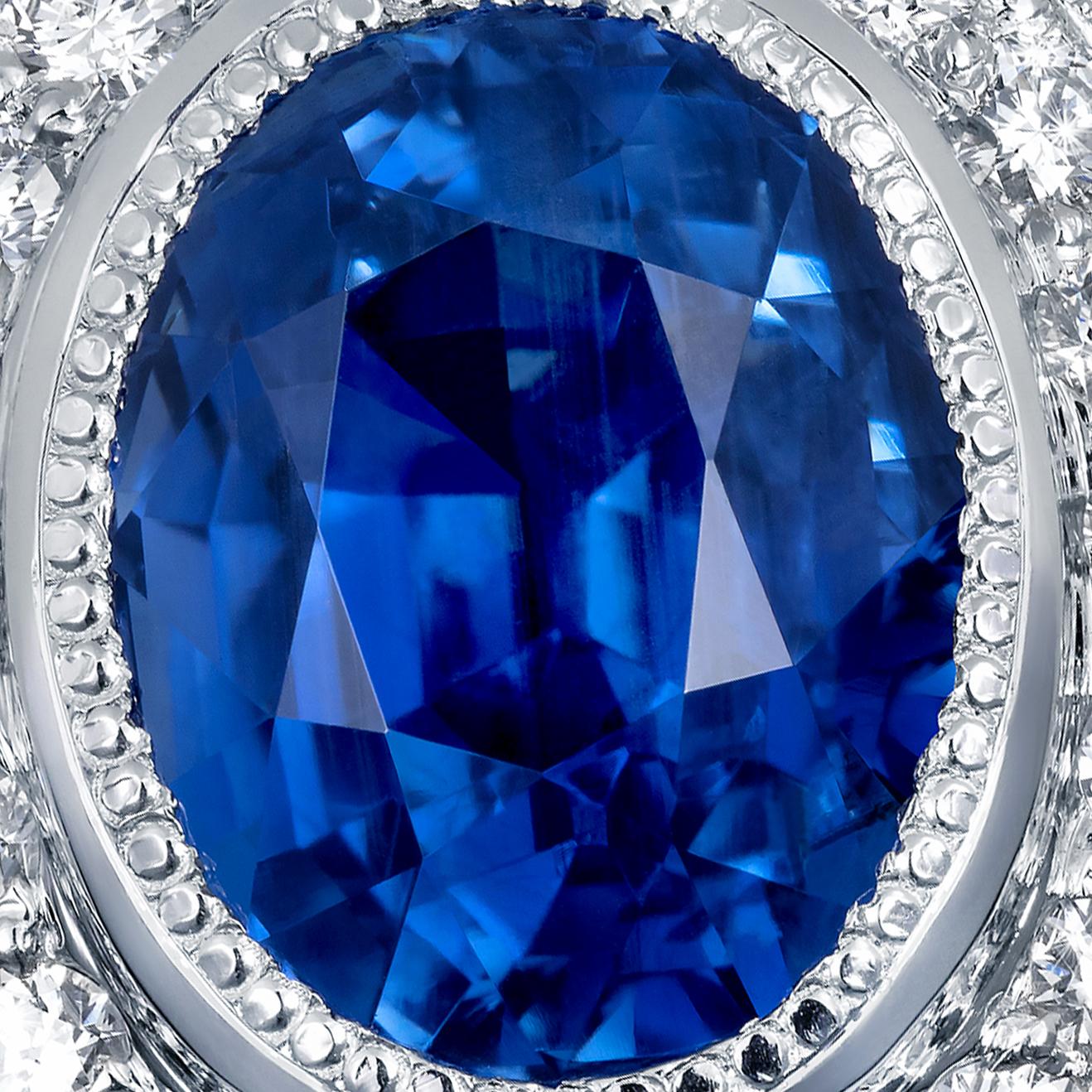 A beautiful royal blue oval sapphire is set amongst diamonds in this unique Regal setting with a beaded edge. This exquisite sapphire and diamond ring features a 3.61 carat oval shape Royal blue sapphire surrounded by a pretty halo of 42 brilliant