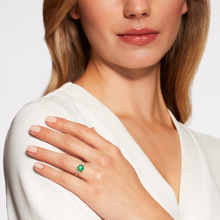 A vibrant emerald from the Muzo mine in Colombia is set in an 18K yellow gold setting with diamond side stones in the Hirsh Trilogy setting.

- 1.47 carat round Colombian emerald with certification
- 2 brilliant cut diamonds totalling approx. 0.50
