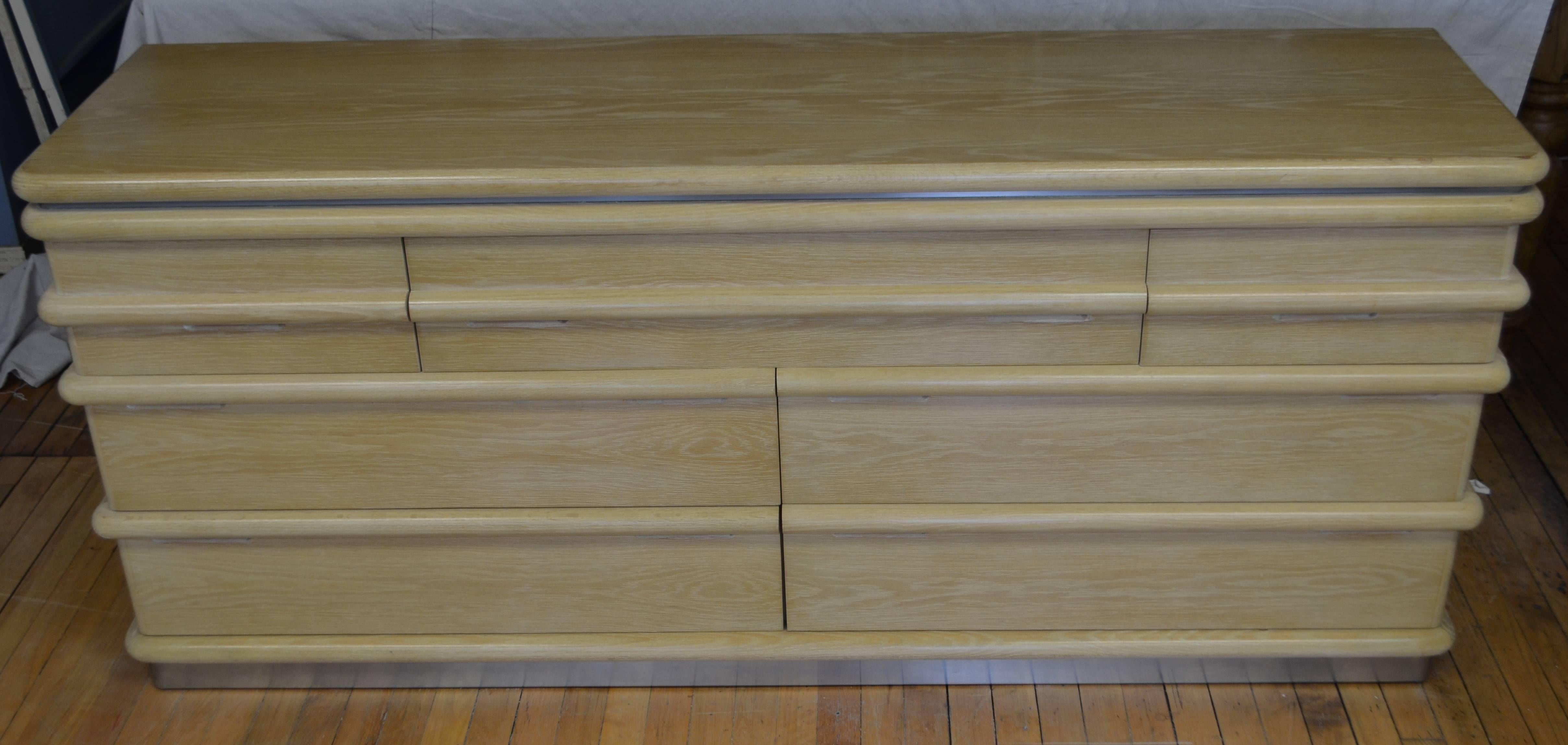 Pair of his and her dressers designed by Jay Spectre for Century Furniture, circa 1970. The dressers are blonde solid oak with dovetail joints, containing seven drawers each. They feature carved rounded borders, wood sculpted, cutout pull handles