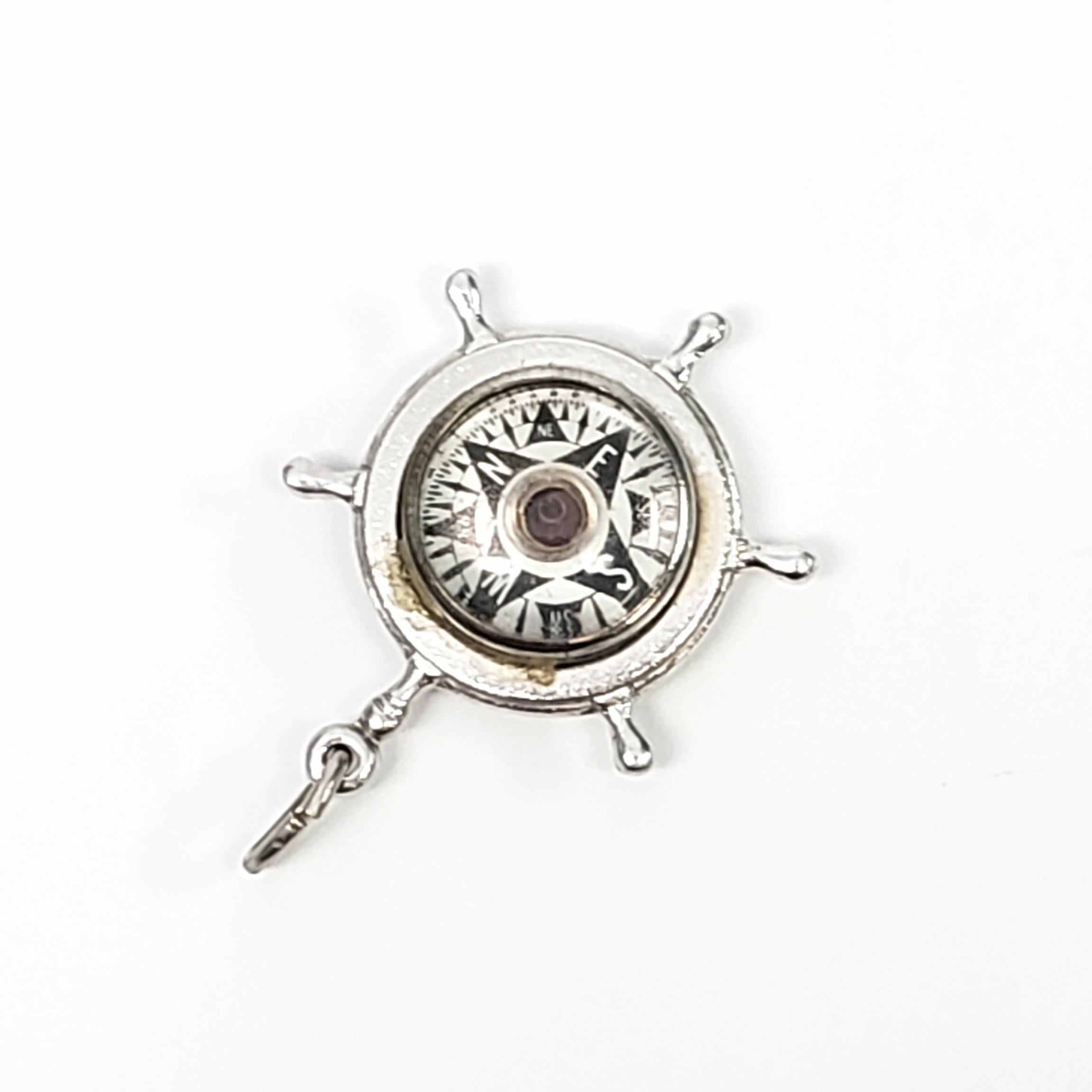 Vintage sterling silver ship's wheel charm with working compass by His Lordship Product Co. of NYC, circa 1957.

His Lordship Products Co. crafted custom jewelry in the 1960's, most were nautically themed items made of sterling, to an affluent