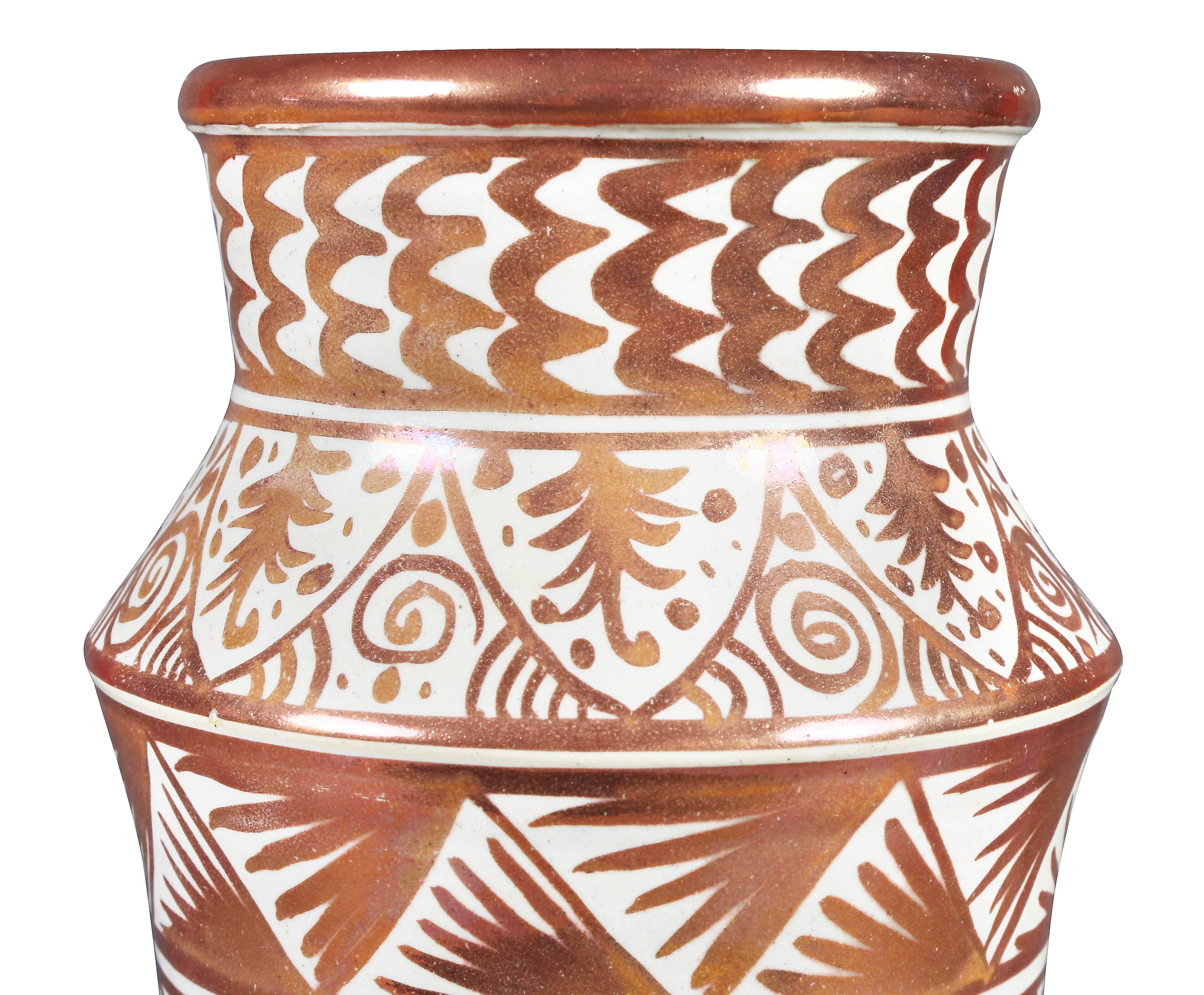 Forme Albarello décorée en rouge cuivre sur fond crème. Signé LC dans un cartouche en trou de serrure.