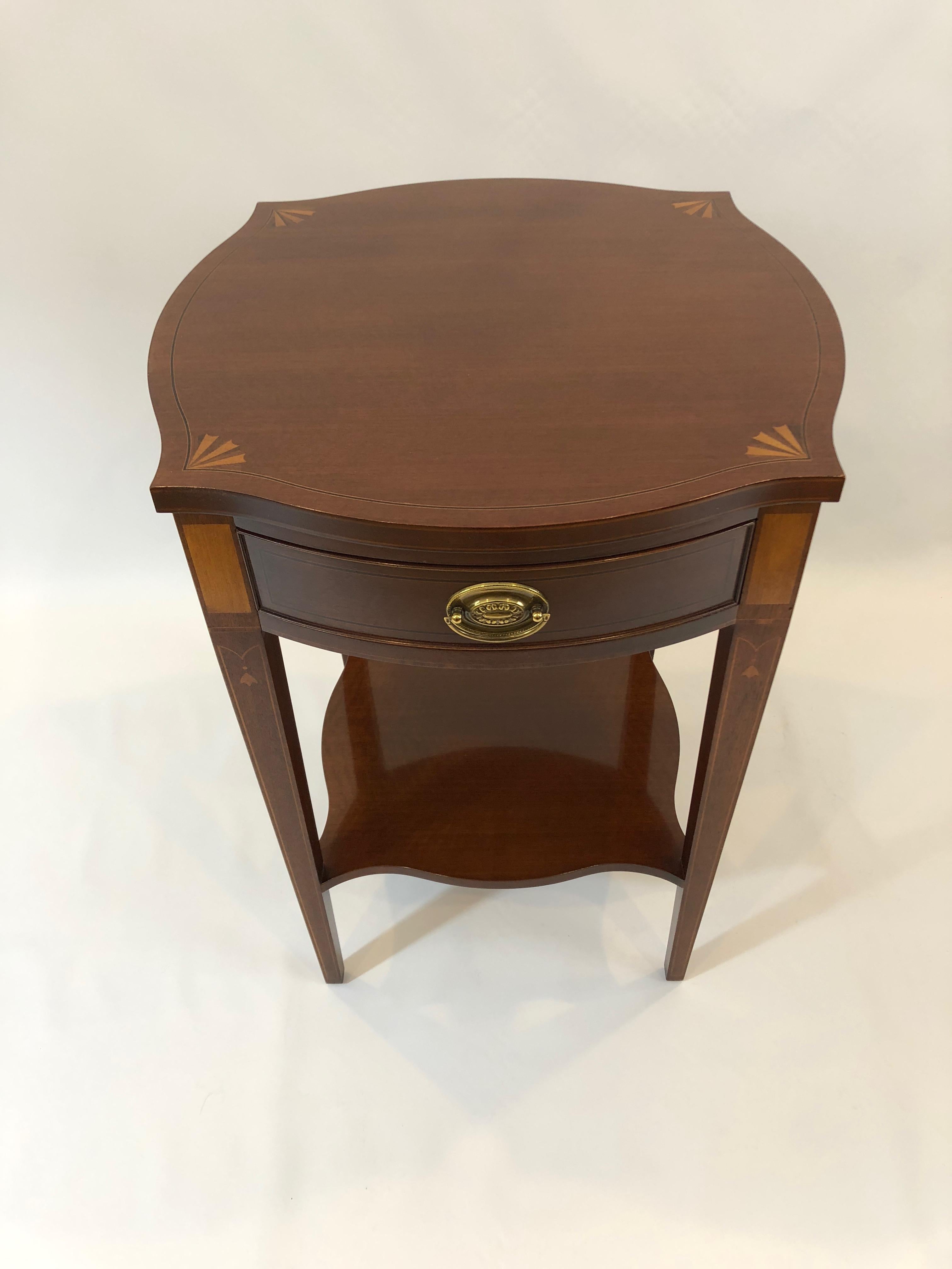 Refined mahogany side table by Baker from their Historic Charleston collection, having a square shape with pretty curvy shaped corners decorated with satinwood and ebony inlaid fans. There's a second tier, lovely tapered legs as well as original