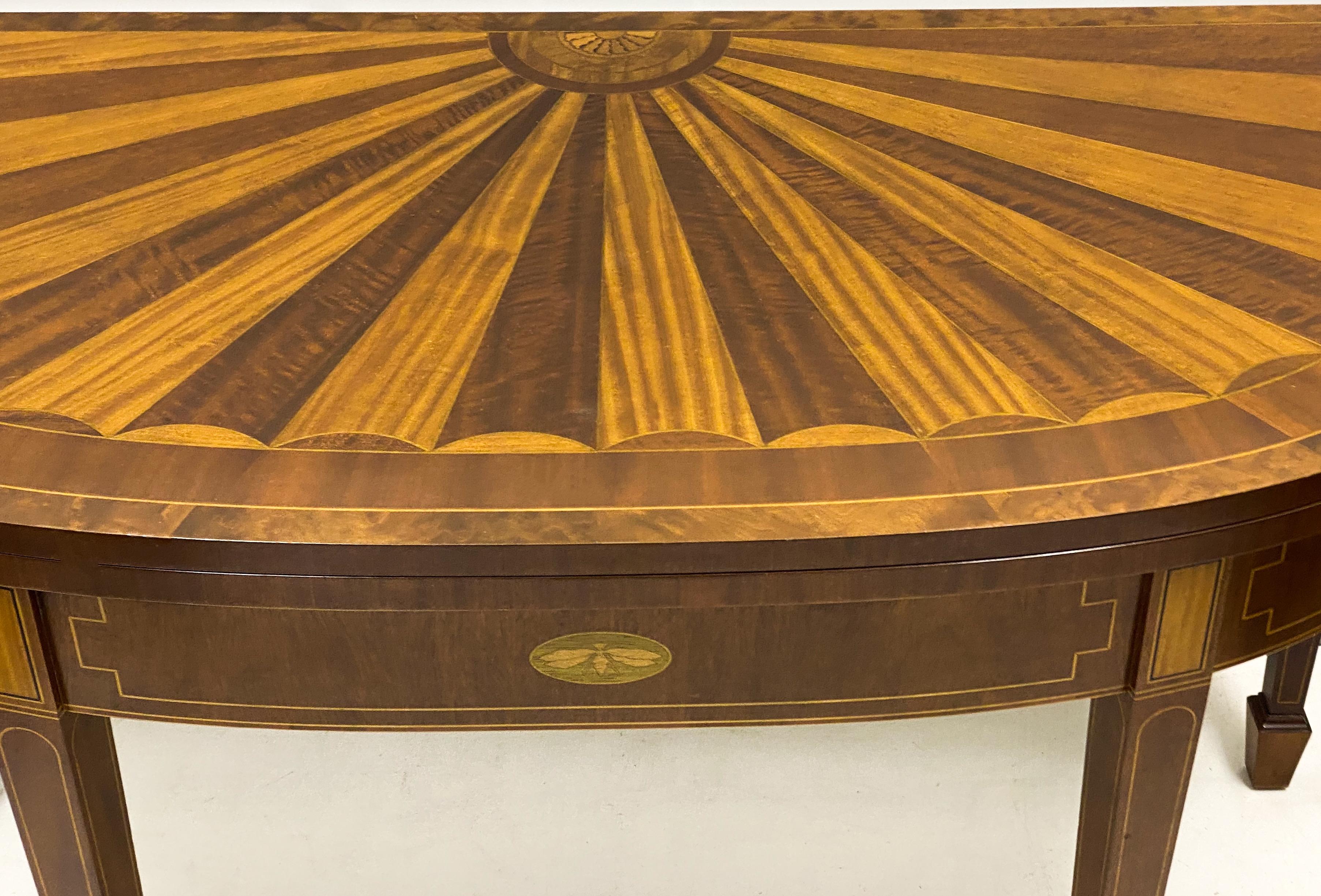 This is a flip top demilune game table with federal styling by Baker Furniture. It is part of their Historic Charleston Collection. The table has two swing support legs, and the green felt is in excellent condition. The inlay is mahogany and