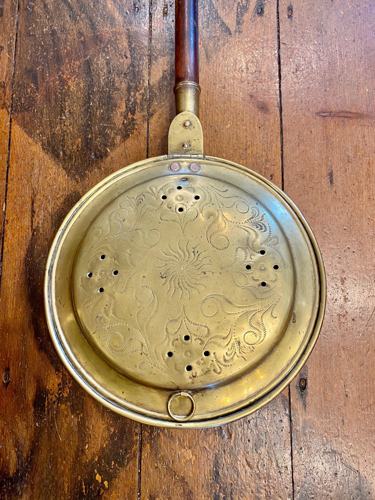 An important and historic revolutionary war period bed warming pan, belonging to Lieutenant James Porter, Jr., circa 1770s-1780s. A hand chased brass warming pan having a hinged lid with central sunburst surrounded by Rococo scrolls and heart-shaped