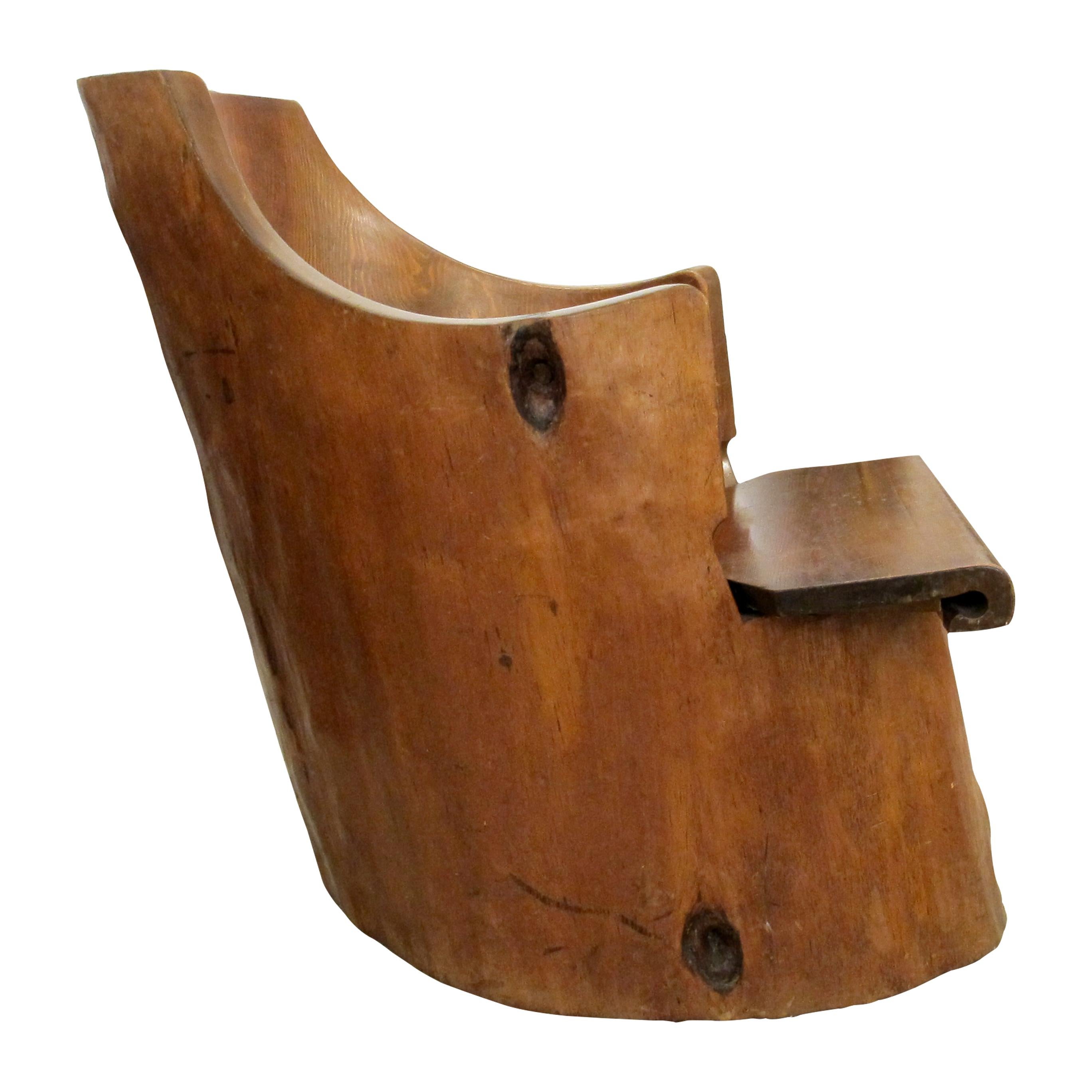 Questa straordinaria sedia rustica è realizzata a mano da un singolo tronco di pino, che le conferisce una forma organica unica e una presenza senza tempo. La sua solida costruzione, unita alla bellezza naturale delle venature del legno, lo rende un