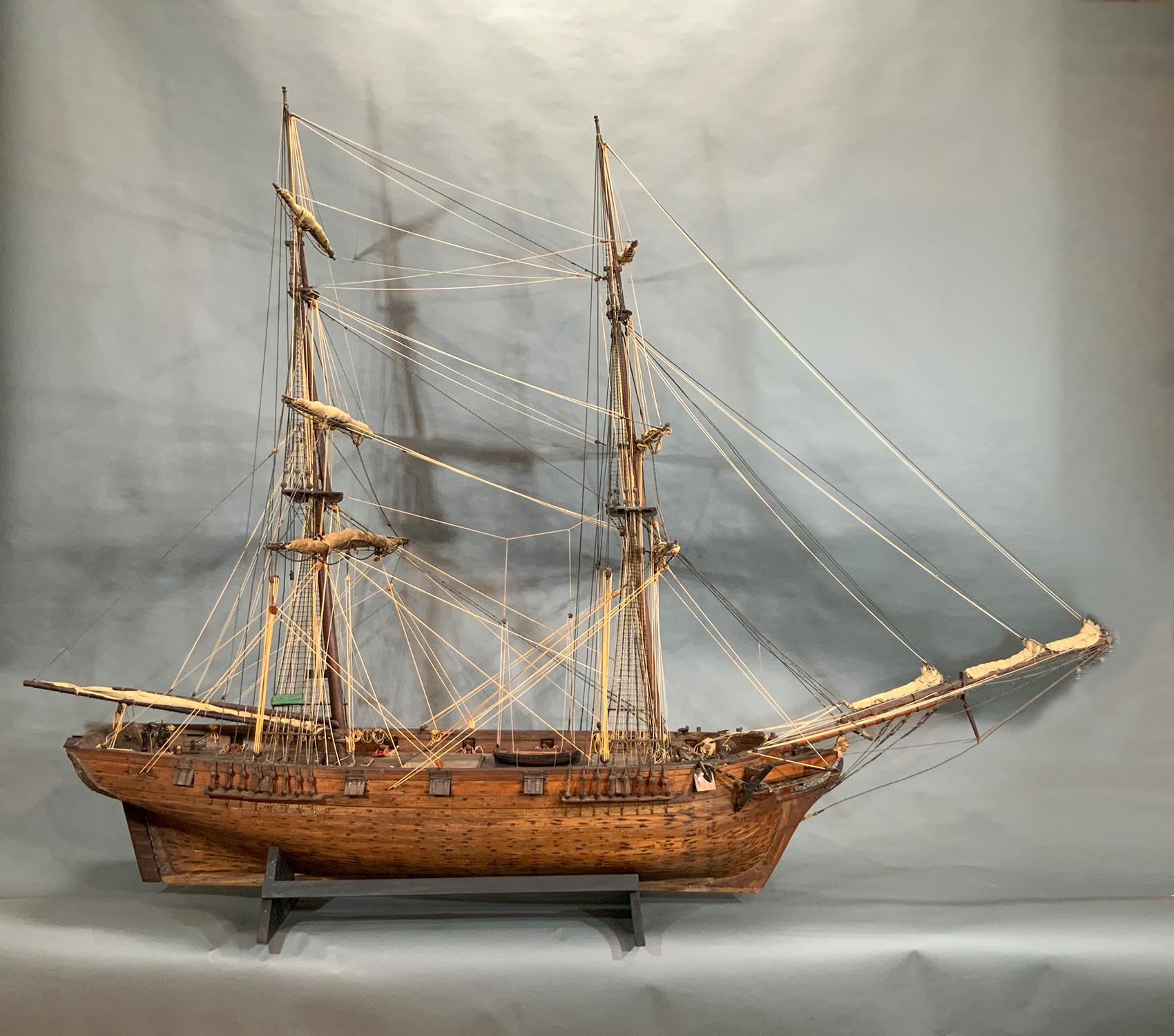 Modelo de barco del siglo XIX de un bergantín americano del estimado Museo Ballenero de New Bedford, antes Sociedad Histórica de Old Dartmouth, con tablas de rastreo talladas, casco y cubierta entablados. Completamente aparejado, velas enrolladas,