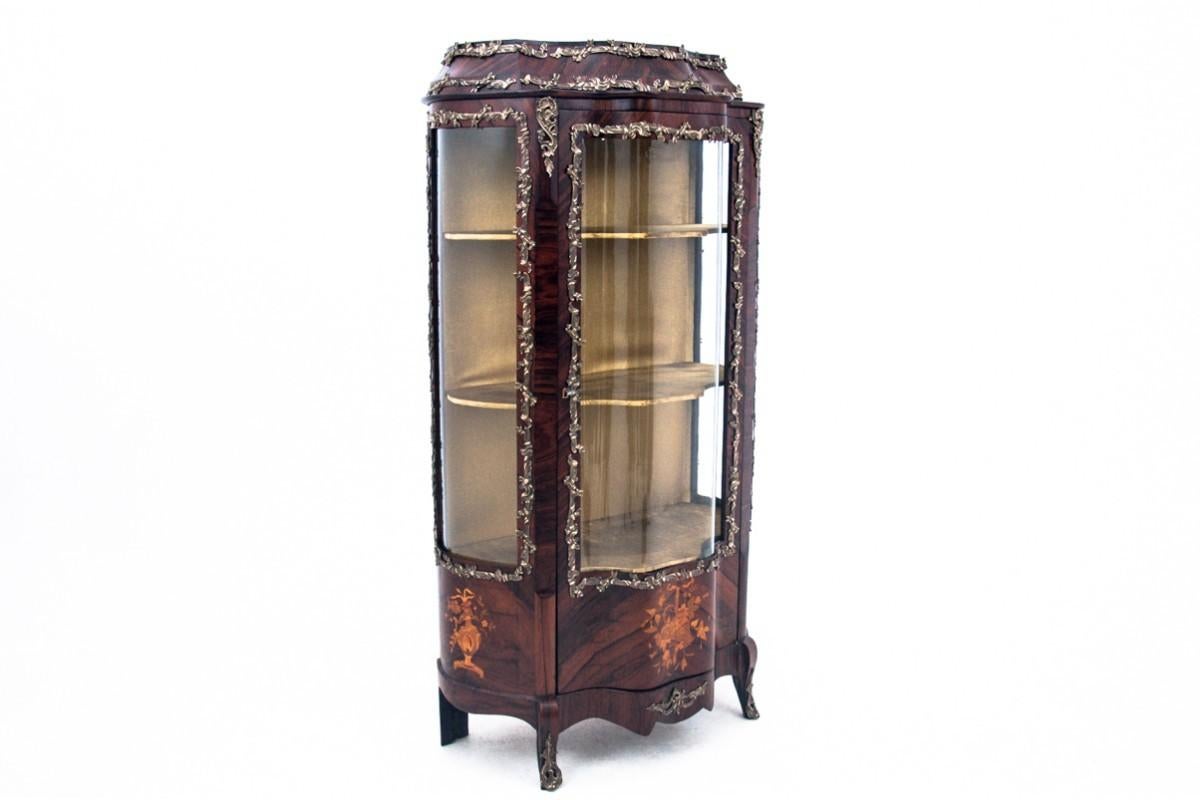 Historische Stätte, Frankreich, um 1830. NACH DER RENOVIERUNG. UNIQUE

Eine antike Vitrine aus Frankreich aus der Zeit um 1830 ist ein wahres Kunstwerk der Möbelkunst. Reich verziert mit Metallelementen und eleganten klassischen Intarsien, zieht sie