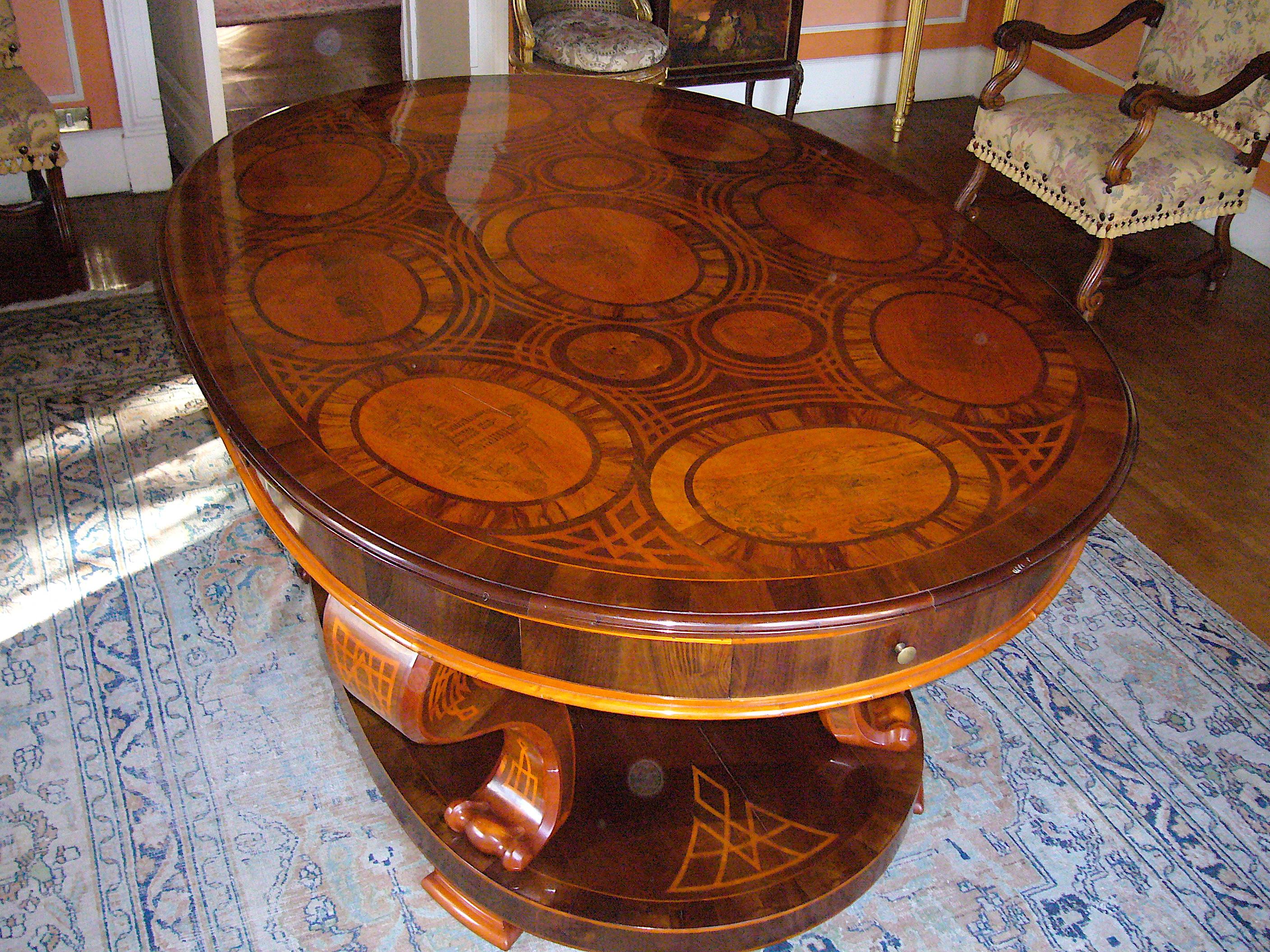 A highly important mid-19th century veneered centre table, with a profusely inlaid top. The tabletop includes marquetry depictions of geometric shapes depicting the history of an important aristocratic descent, centered by a Coat of Arms of the