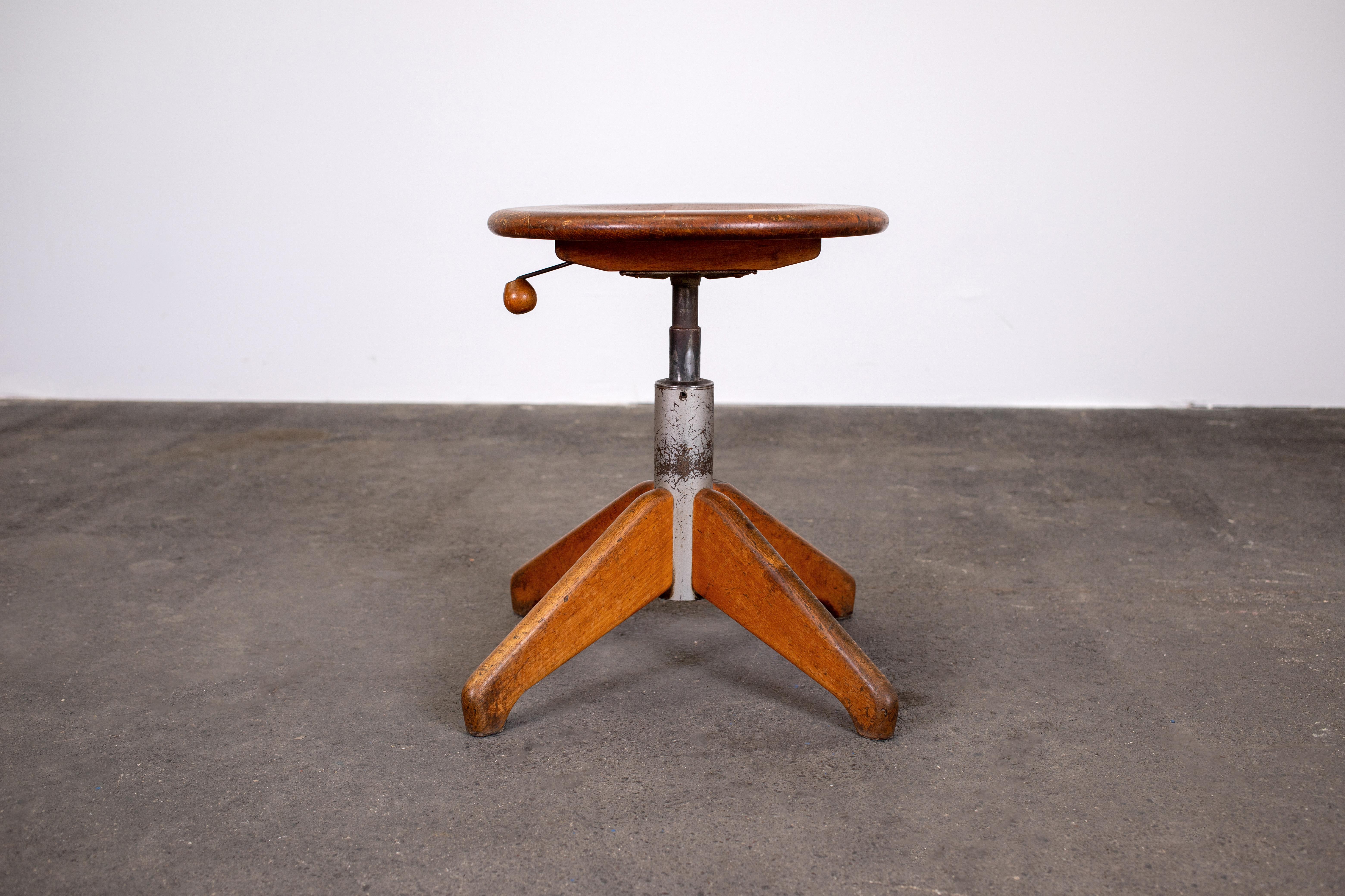Historical Mid-Century Modern Swiss German Industrial swivel stool by Albert Stoll II for Giroflex Stoll, Switzerland. Ergonomic round dimpled oak seat sits atop the first patented spring cushioning system made of steel. Flanked with torpedo-wing