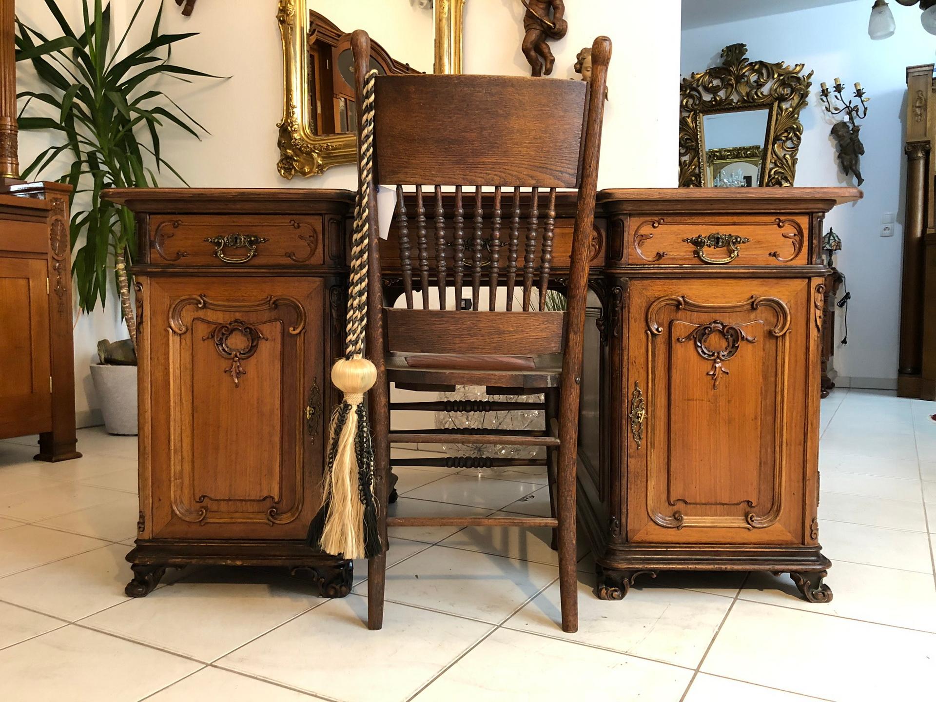 Antique Baroque Revival or Historicism desk made, circa 1885. The beautiful piece features baroque design elements and is made out of solid oak wood with a wonderful color. It offers plenty of storage space behind two large doors and within five