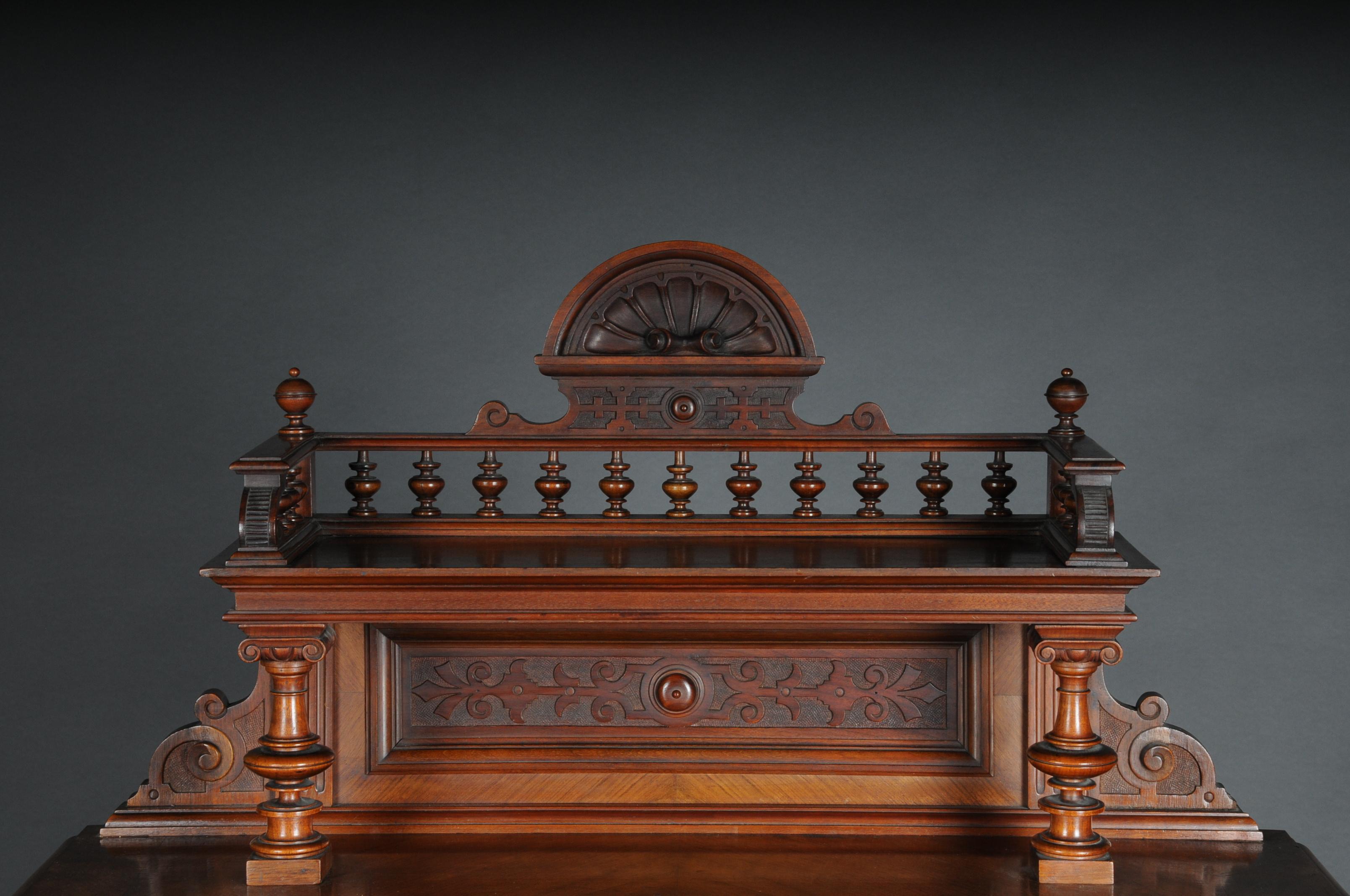 Historicism cabinet top cabinet / sideboard circa 1870, walnut

Walnut with rich decorative carving. Two-door body with columns and drawer. Cake stand with gallery frame and shell top. Brass handles and decorative fittings, circa