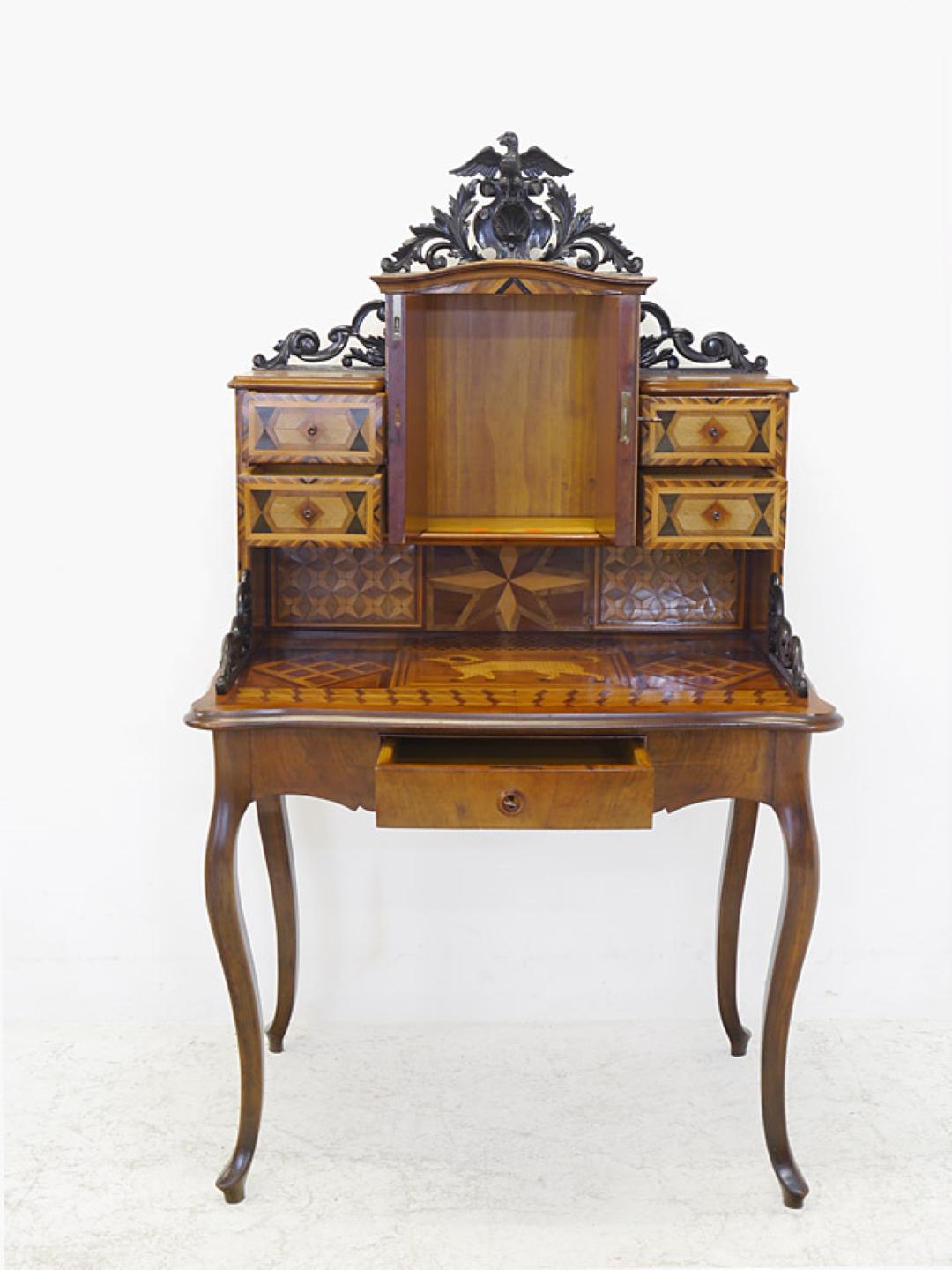 Extraordinary historicism bureau or secretary circa 1880 made of walnut with connected inlays made of different fruit woods. The top offers ebonized open worked moldings including beautiful inlaid work in the form of ornamental and animal motifs.