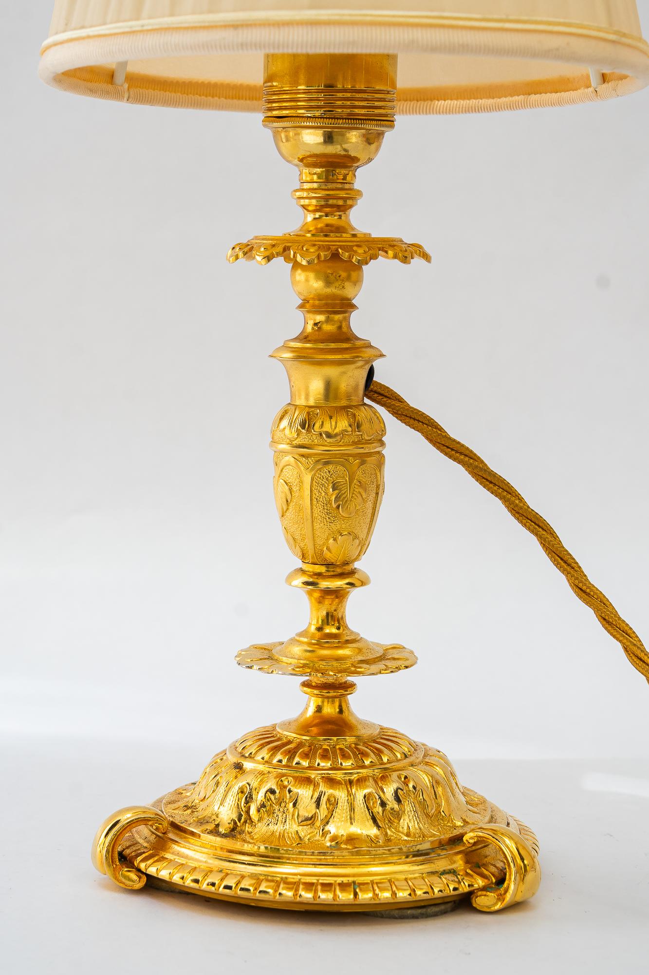 Historistic fire gilted table lamp with fabric shade vienna around 1890s
Original condition
The fabric shade is replaced ( new )