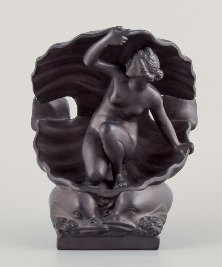Hjorth, Bornholm.
Rare sculpture in black terracotta.
The Birth of Aphrodite.
Nude woman in a seashell and two fish.
Model number 588.
Early 1900s.
Marked.
In excellent condition with minimal signs of use.
Dimensions: H 23,0 cm. x W 19,0 cm.




