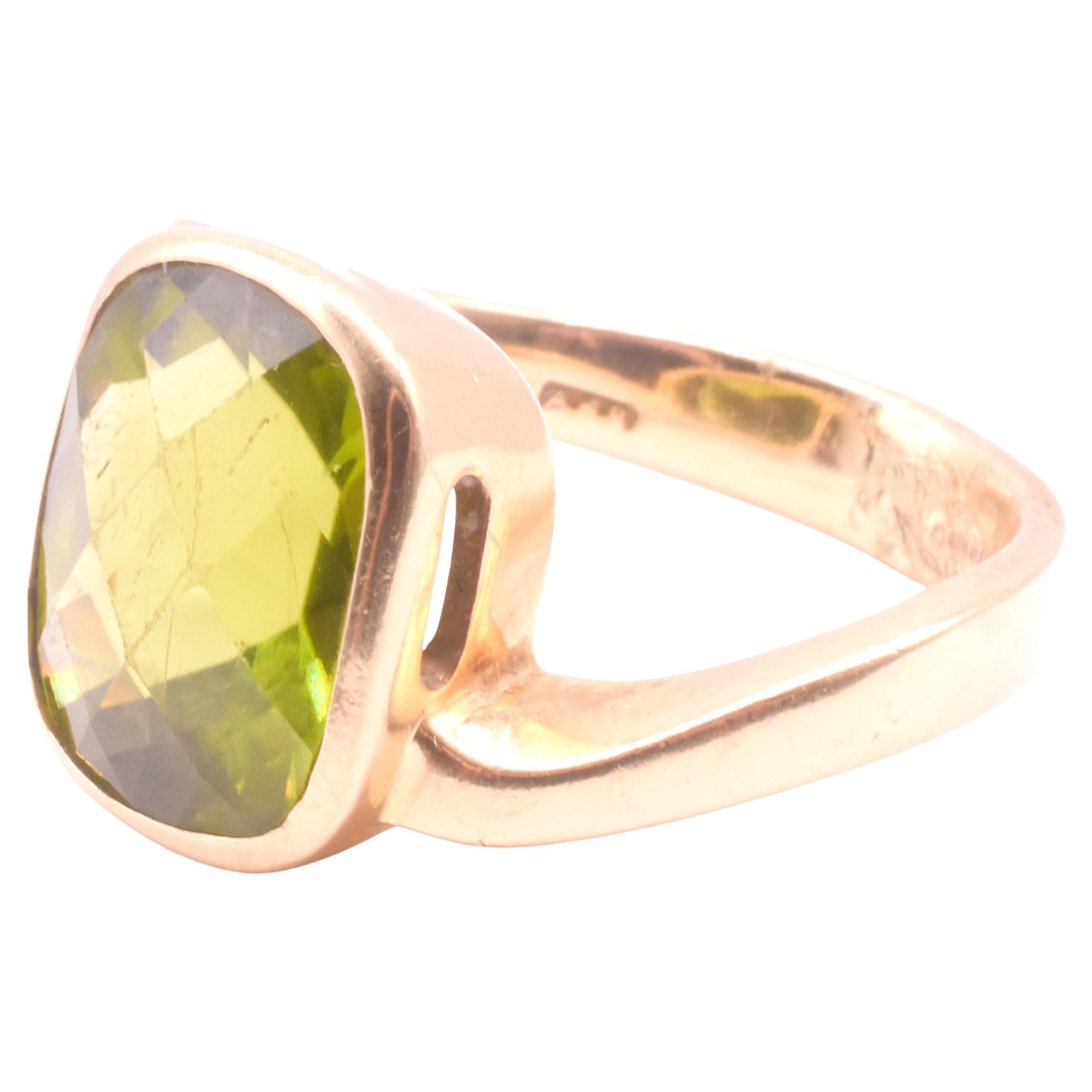 Bague solitaire contemporaine en 18K avec une pierre péridot facettée d'une belle couleur vert clair et un jeu de poinçons anglais indiquant la date de production de 2001. Un côté de l'anneau rejoint la face de la bague en haut tandis que l'autre
