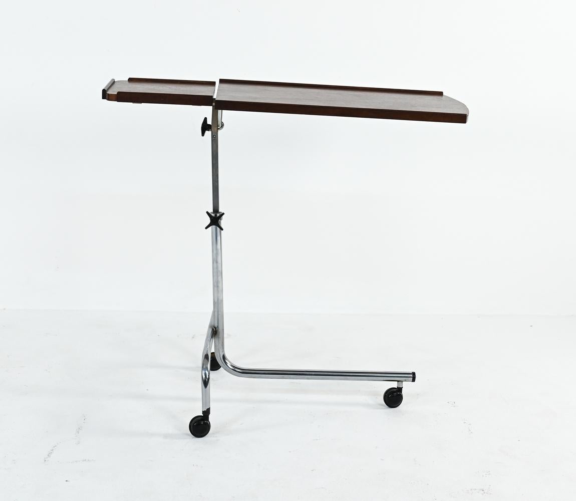 A fabulous Modernist take on the traditional Victorian reading table, this piece features a base of tubular bent chrome and a minimalist segmented rosewood top, with stationary drinks tray and tiltable stand. This table would be perfect for a