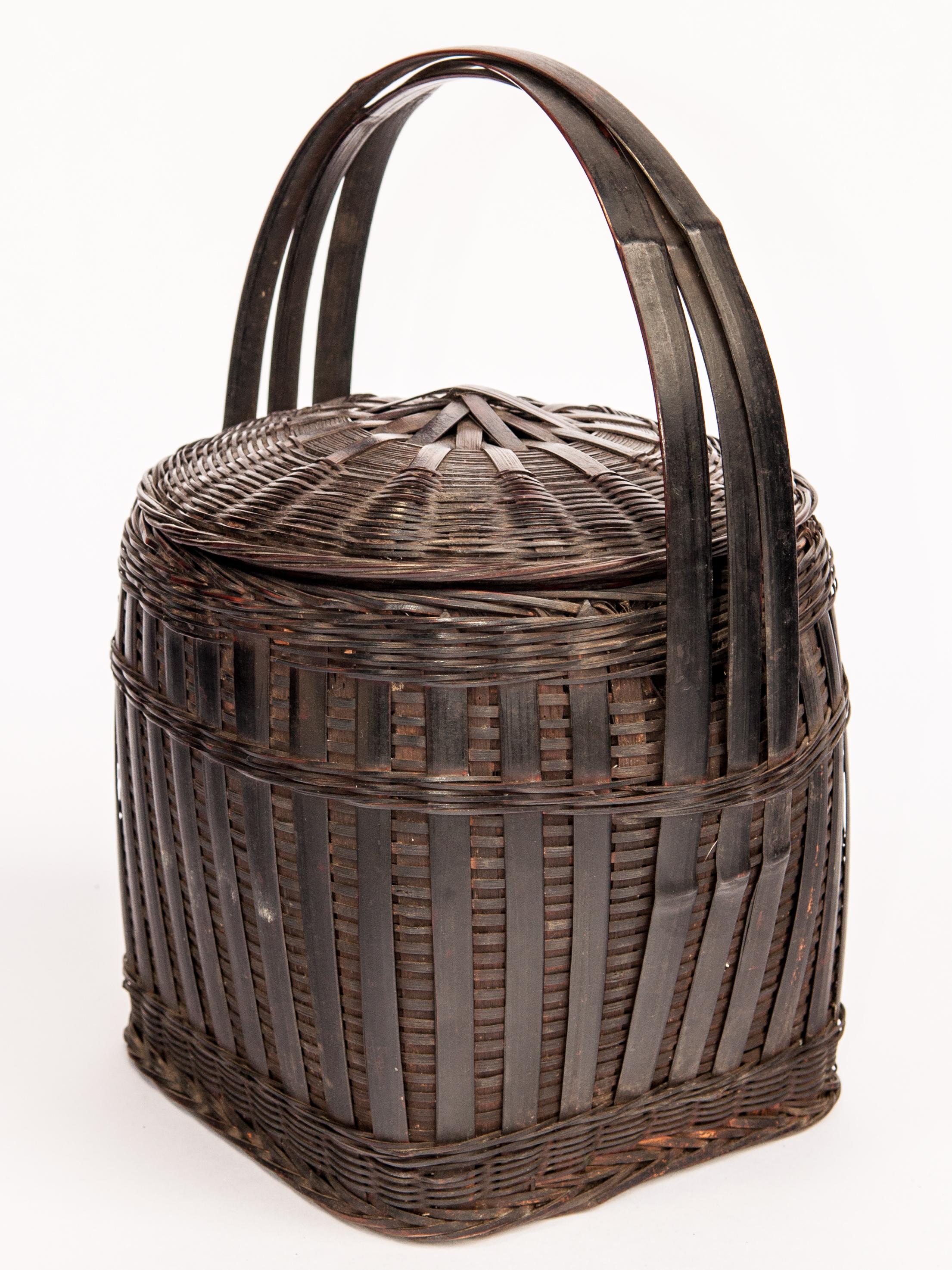Hmong storage basket with lid and handle. Guizhou, China. Mid-20th century.
This strongly constructed utilitarian basket is hand made of bamboo and is imbued with a fine dark patina. It comes from a Hmong village in Guizhou, China, and was used as