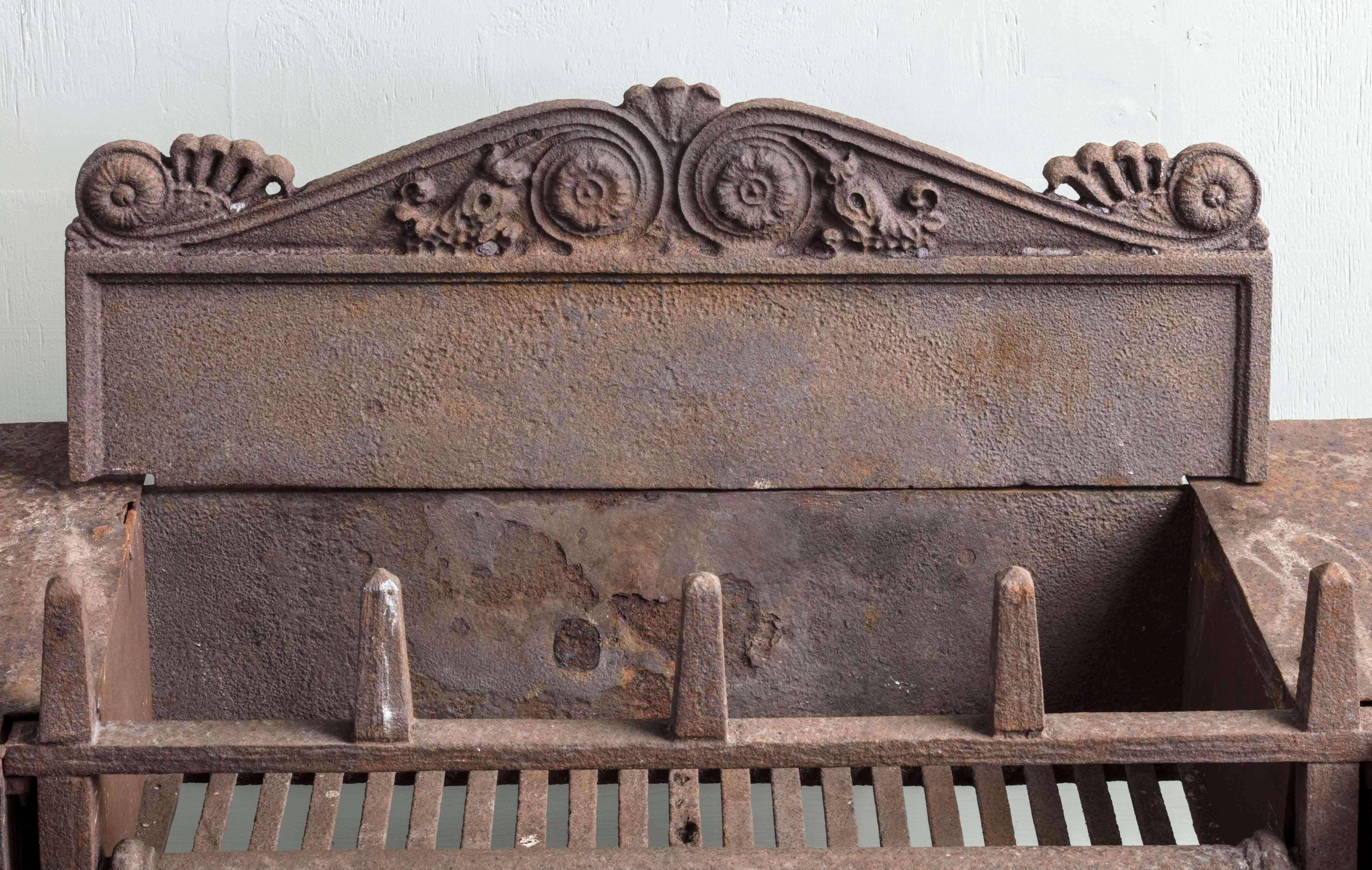 An exceptional quality over scale country house hob grate, c.1820, in the Grecian revival style. Severe in design yet fine in quality, it has been fully restored to retain its original, sleepy surface, with unpolished bronze details on the