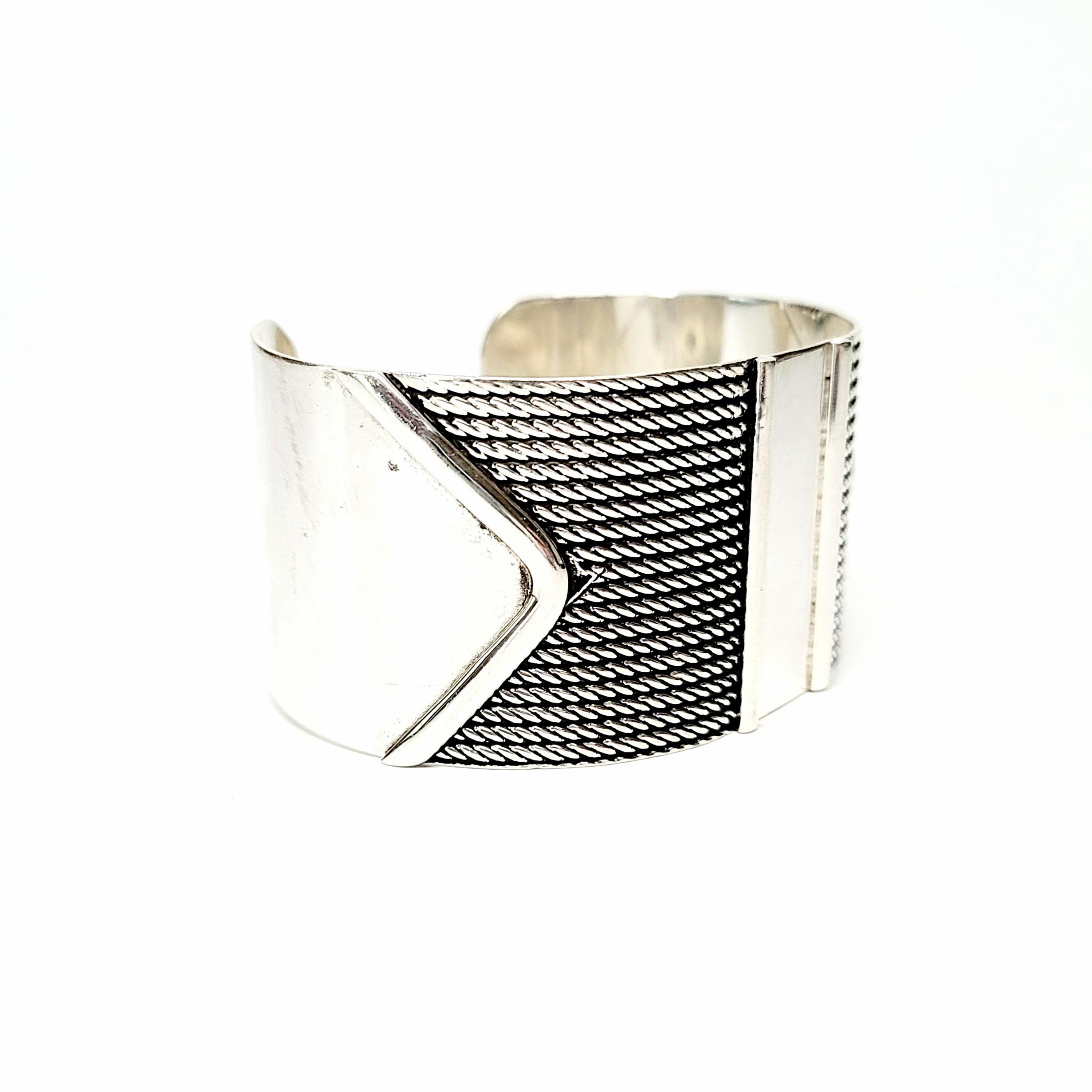 Sterling silver cuff bracelet by House of Bangles Mexico, signed HOB.

A modernist wide cuff bracelet with unique and interesting design featuring smooth, polished ends and center, combined with lines of twisted rope.

Measures approx 6 1/4