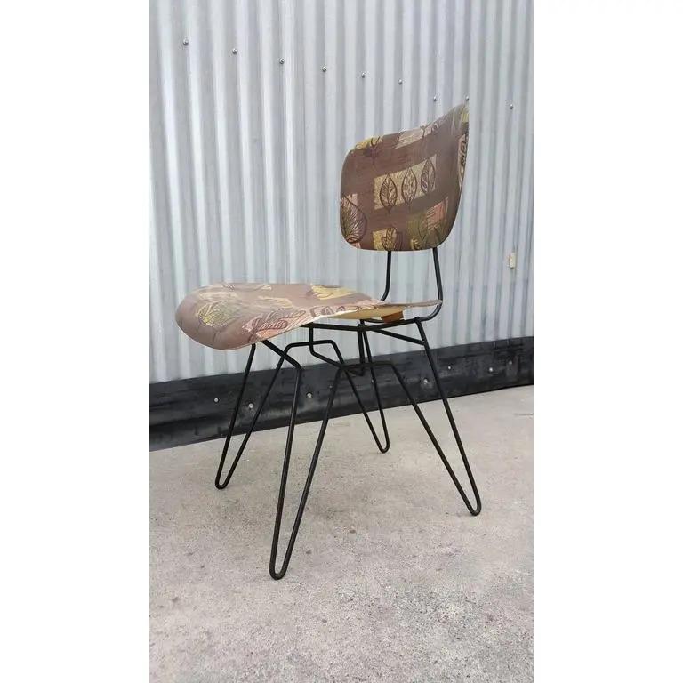 A unique variation on the Classic Eames Mid-Century Modern design with a floral pattern formed fiberglass seat and backrest floating on an iron hairpin base. Shock mounts used are similar to the style used in the Charles & Ray Eames fiberglass