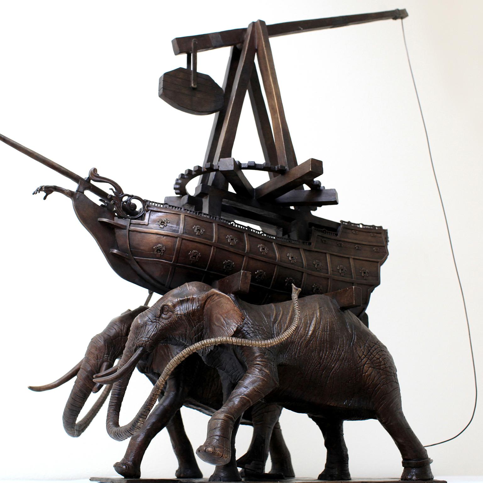 The Elephants by Hobbes Vincent. 
Bronze
36 x 17 x 15 inch
Edition 3 of 12

Solid Bronze sculpture of two elephants carrying a warship with a trebuchet. A sailboat between the elephants legs also emphasizes the surrealism of Hobbes work. The warship