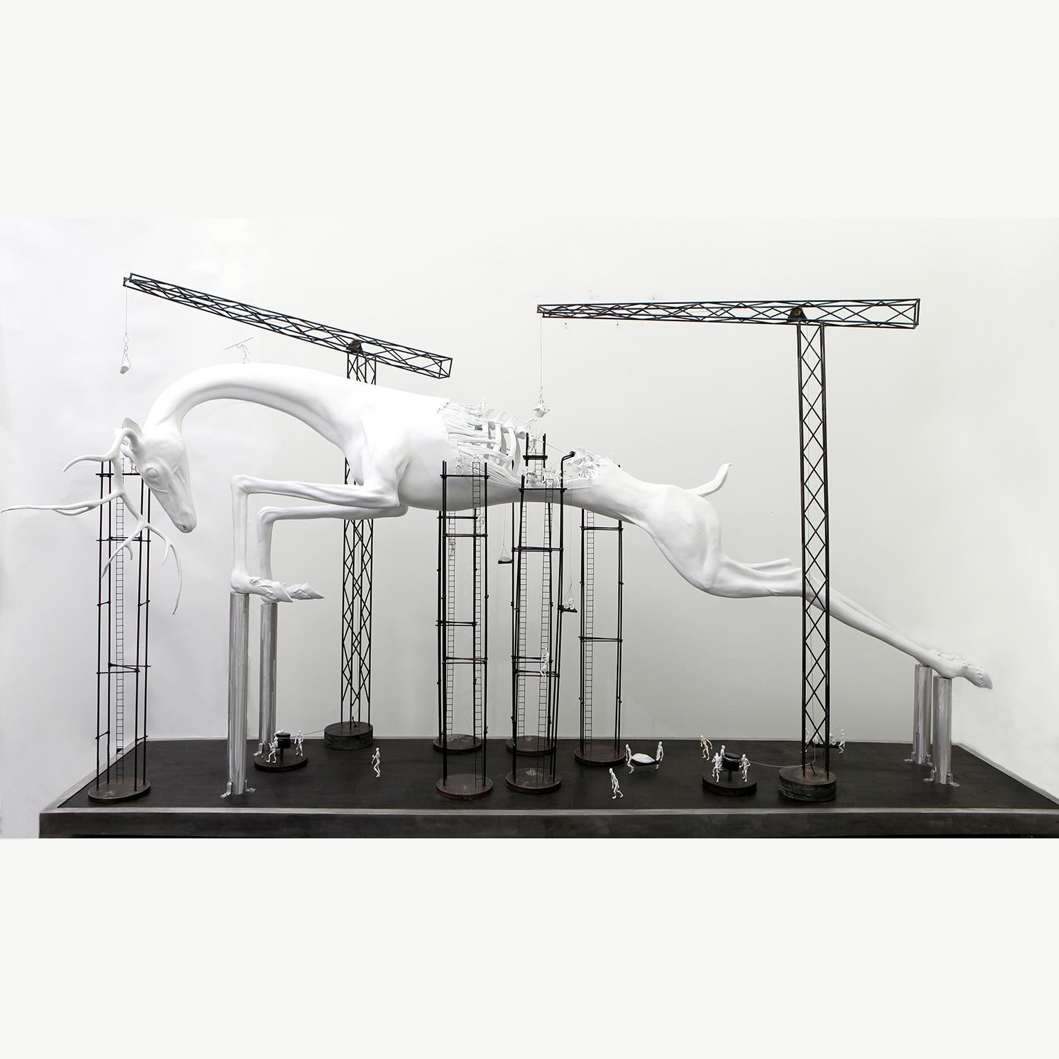The Stag by Hobbes Vincent is an original steel, plaster and resin sculpture. 
84 × 168 × 48 inch; 213.4 × 426.7 × 121.9 cm

This sculpture features a stag and building cranes and workers who appear to be assembling the stag piece by piece. 

This