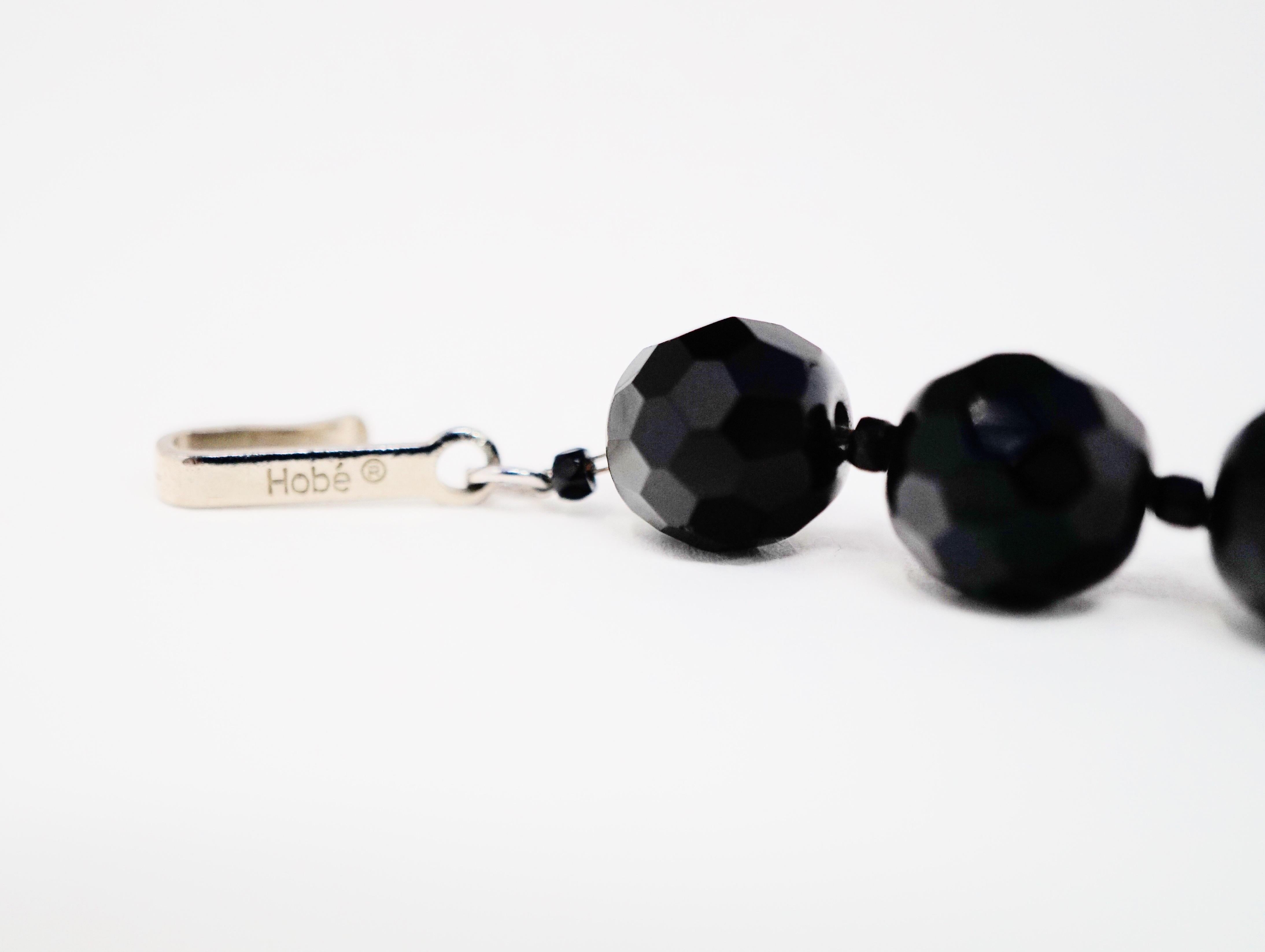 This gorgeous circa 1960s Hobé choker necklace features deep black faceted onyx beaded gemstones and accented with smooth onyx rondelle spacers.  An extremely collectible piece of design history, this choker is stylistically relevant today as it was
