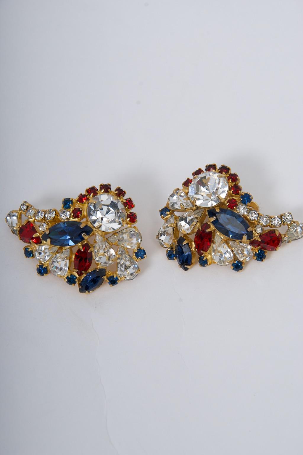 Hobé earrings featuring clear, sapphire, and ruby crystals in a goldtone metal paisley shaped frame. Signed 