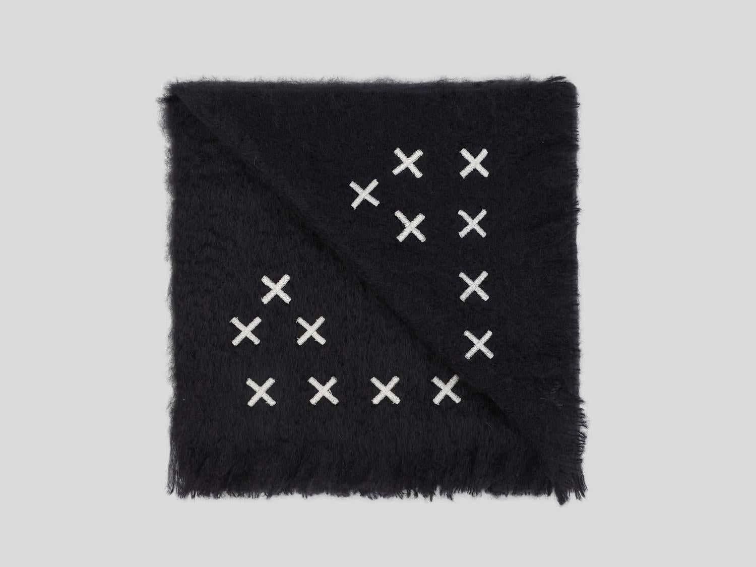 Hocken, a unique graphic black blanket made of the finest New Zealand mohair. This throw is embellished with small cream crosses embroidered by hand. Nothing as personal as your own interior, the colors of the fabric and embroidery can be customized