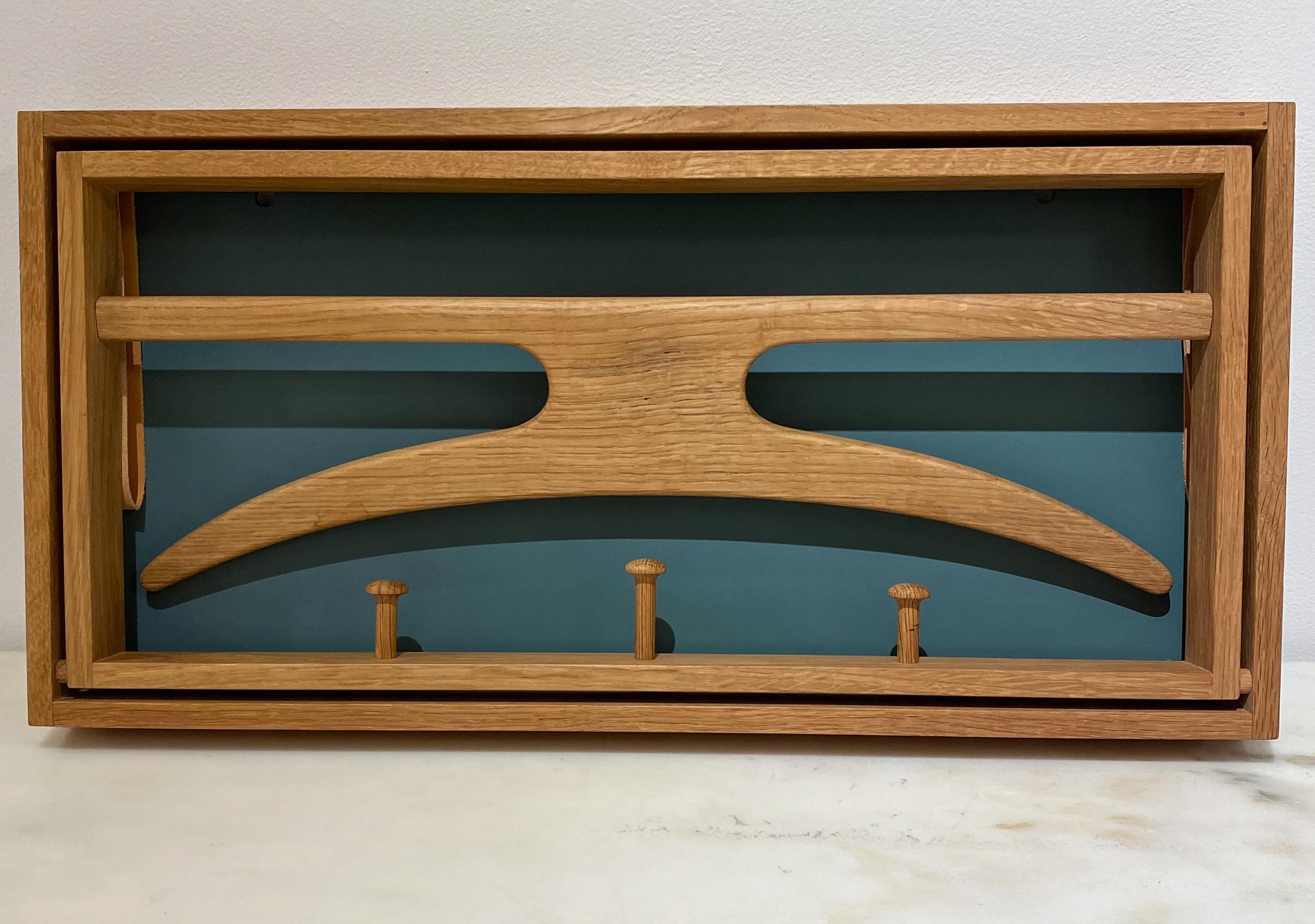 Wall-mount valet in oak with leather straps and lacquered masonite back panel by Adam Hoff and Paul Ostergaard for Virum Mobelsnedkeri, Denmark, c. 1960's. A sculptural and flexibly functional composition with nice details, including the dovetail