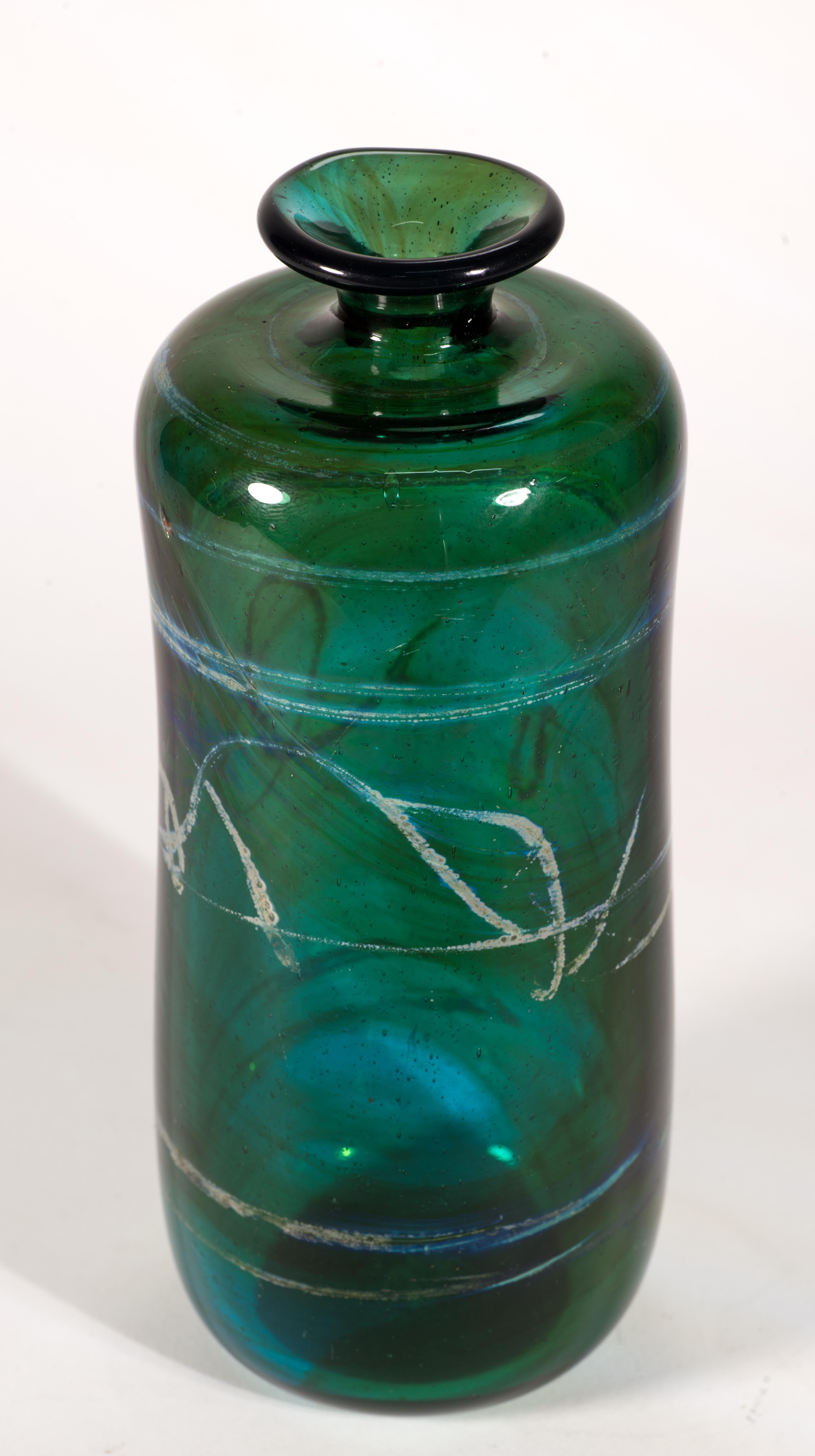 Il raro vaso in vetro organico moderno presenta un motivo grafico astratto di vetro bianco sporco e metallizzato fuso su uno sfondo verde foresta dai toni profondi e gioiosi. La disposizione dei motivi accentua la forma minimale e leggermente curva