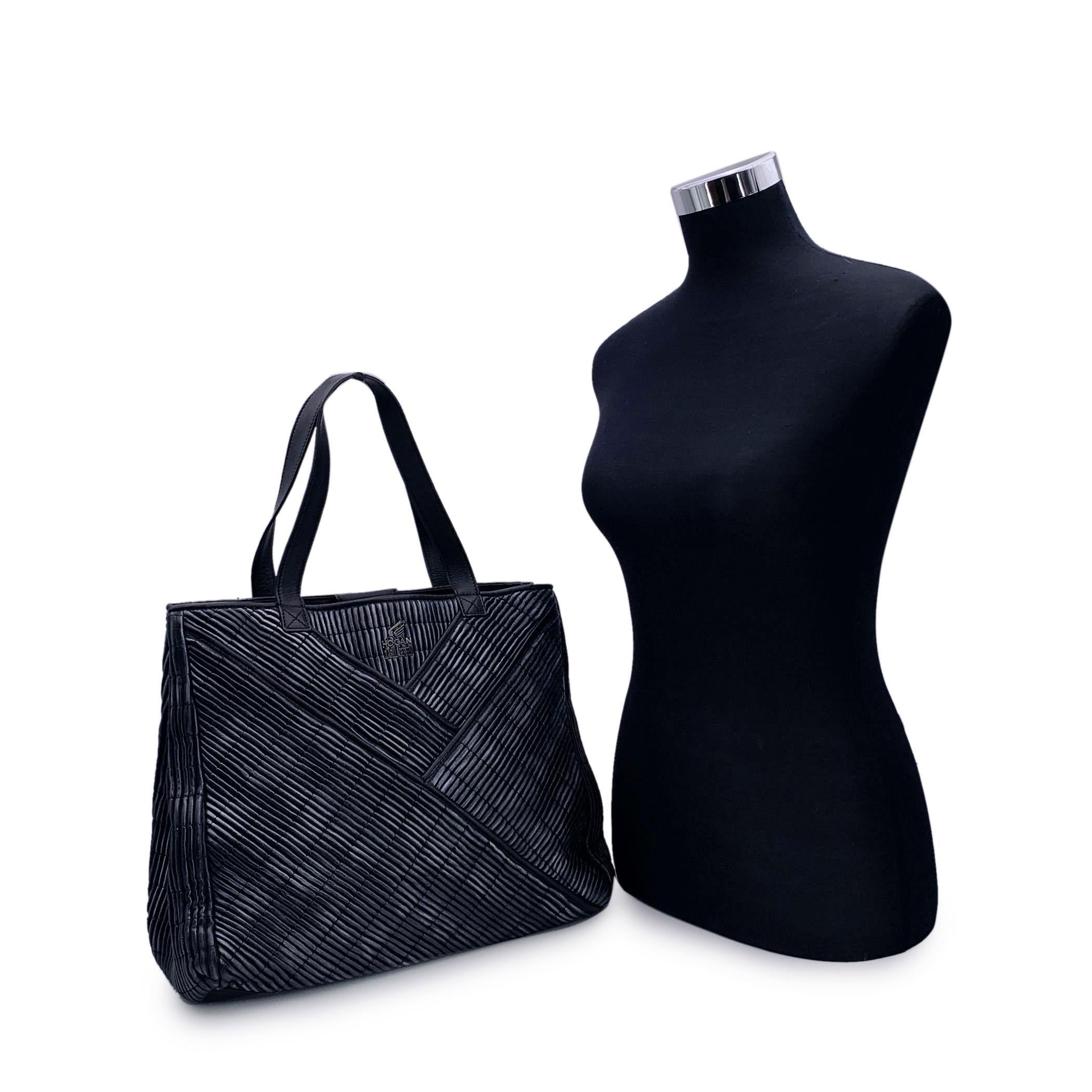 Hogan by Karl Lagerfeld Tote bag.. Black textured leather with laminated effect. 2 front pockets. Magnetic button closure on top. Double handles. 2 main compartments with 1 middle zip sections. 1 side zip pocket inside. 'HOGAN by Karl Lagerfeld' tag