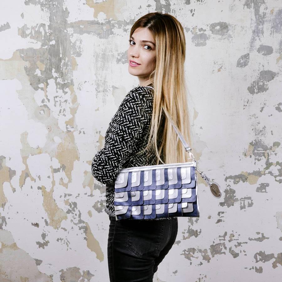 Hogan unisex clutch designed by Karl Lagerfeld in silver leather. At the front of the leather bands silver and petrol blue with embossed engraved name.

It is lined in monogram canvas with a slit pocket. 

Worn by hand or on shoulder with a
