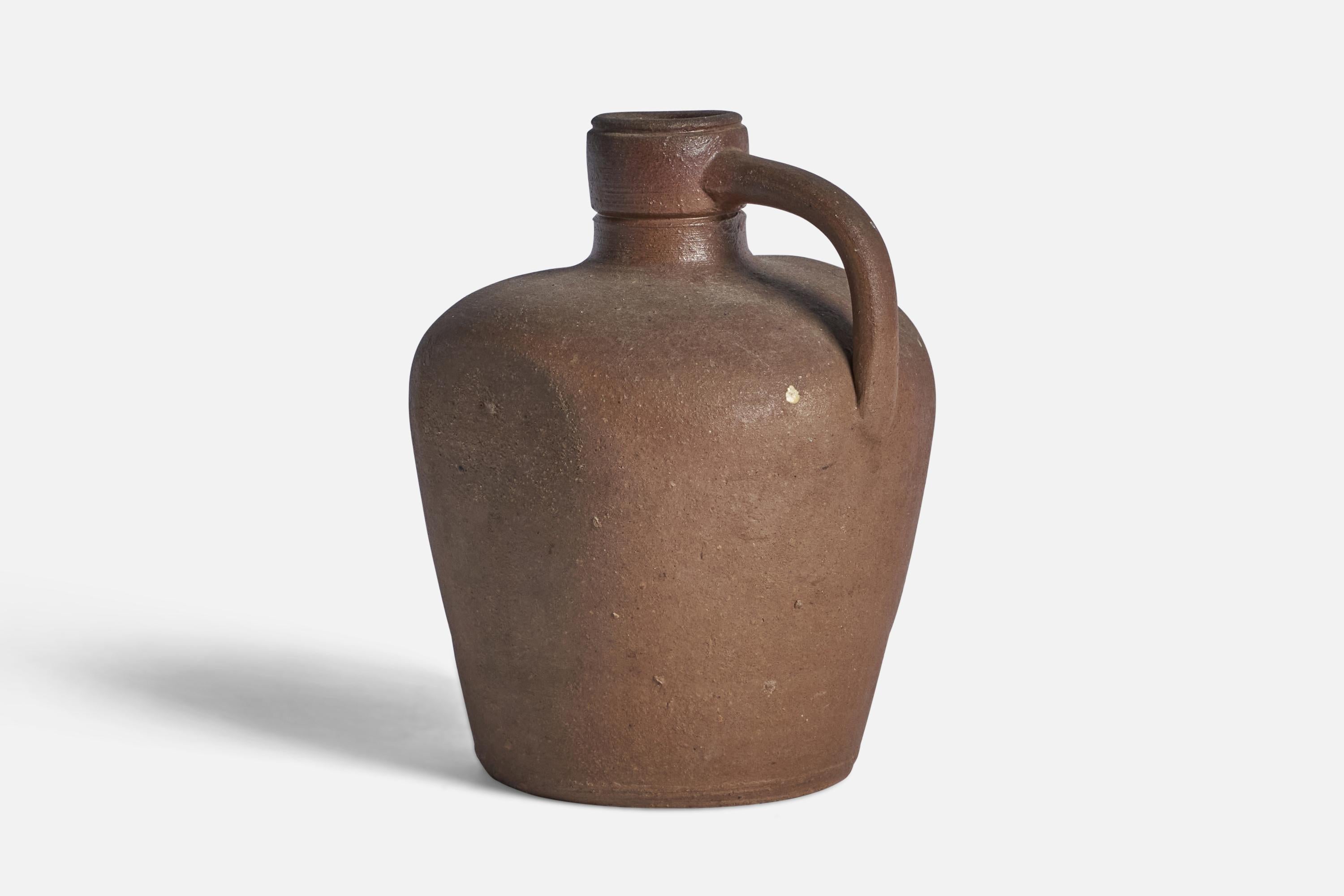 An unglazed brown stoneware pitcher designed and produced by Höganäs Keramik, Sweden, 1930s.