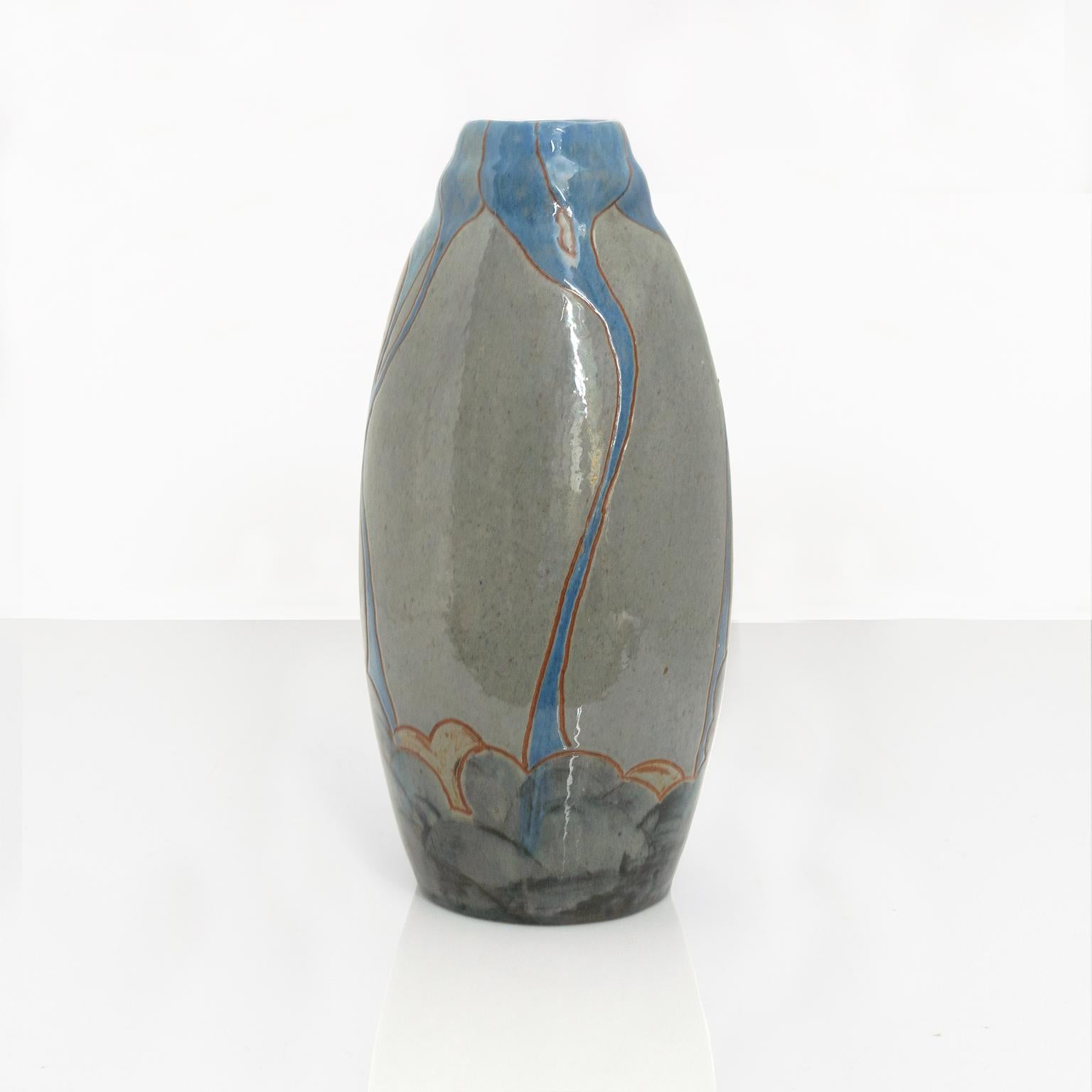 A Swedish Art Nouveau organically shaped ceramic vase with languid lines in blue glaze over a neutral gray body. Made by John Andersson for Hogans, circa 1910. Signed on bottom. 

Measures: height: 10.5“, diameter: 5“.