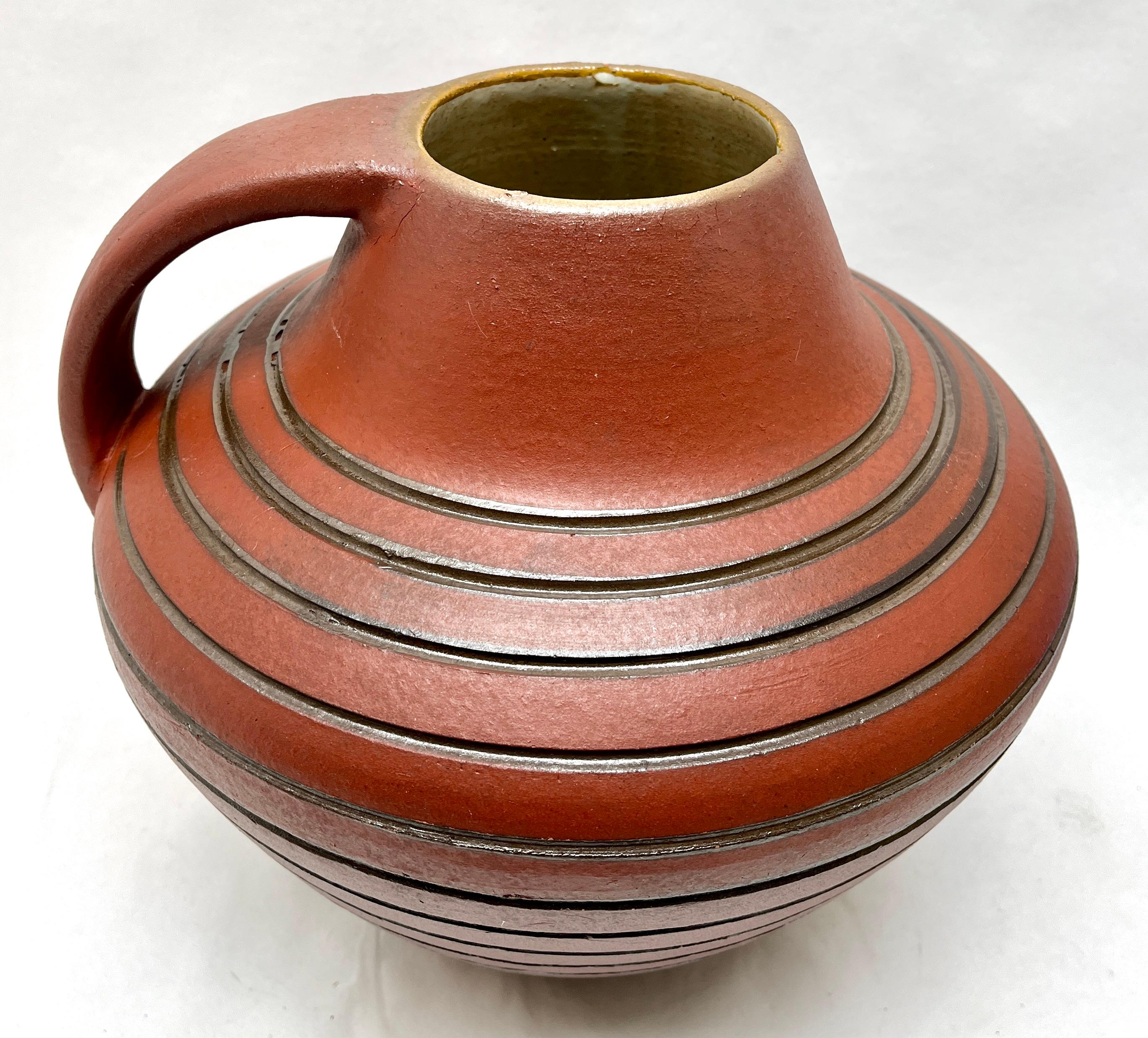 Höhr vintage, Keramikvase mit Henkel 

Diese original Hohr Vintage-Vase wurde in den 1960er Jahren in Deutschland hergestellt. 
Sie ist aus Keramik gefertigt.
Auf dem Boden ist die Vasen-Seriennummer 741/24 Hohr W Germany angegeben. 
Geradliniges
