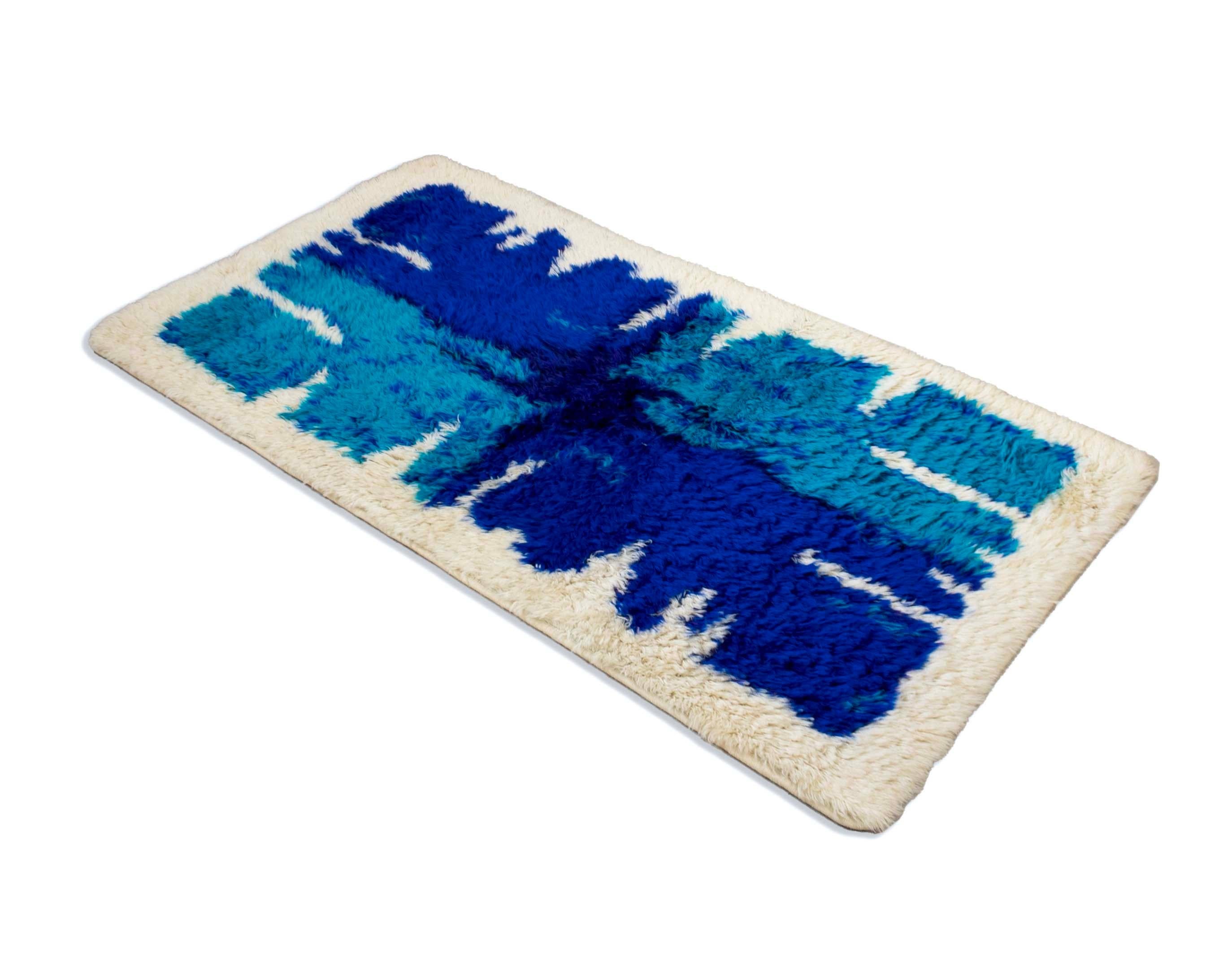 Vibrant and mesmerizing, this Hojer Eksport Wilton Danish Blue and Purple Abstract Design Rya Rug captivates with its lush, deep shades of blue and purple, set against a creamy white background. Crafted in Denmark, it showcases the exceptional